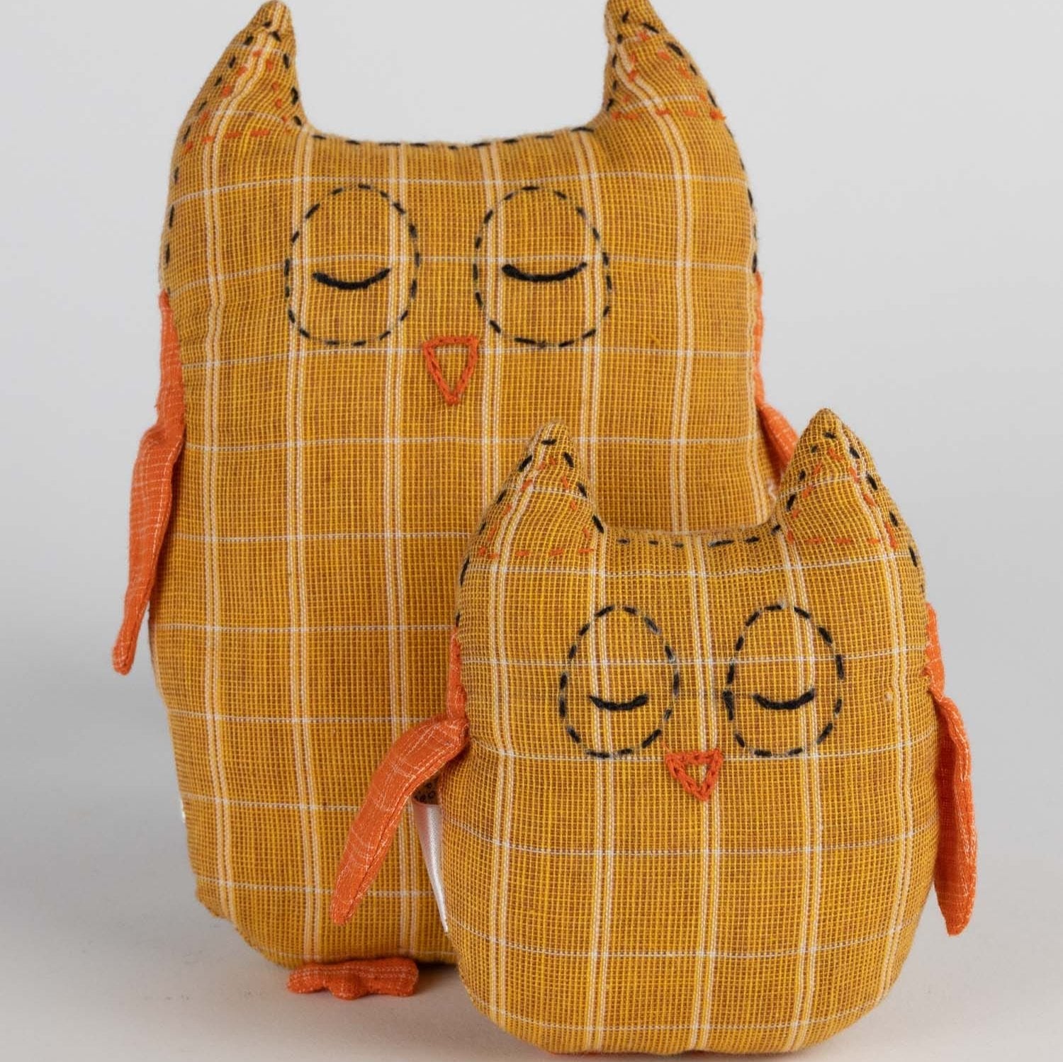 Handmade plush owl pair for kids cuddling in a cozy setting