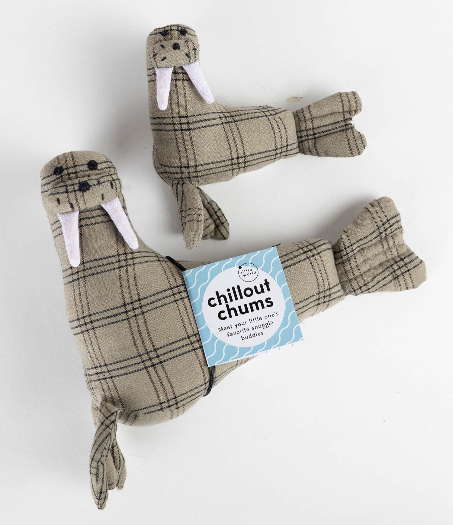 Close-up of handcrafted walrus plush toys Havarti and Huckleberry sitting on a cozy blanket