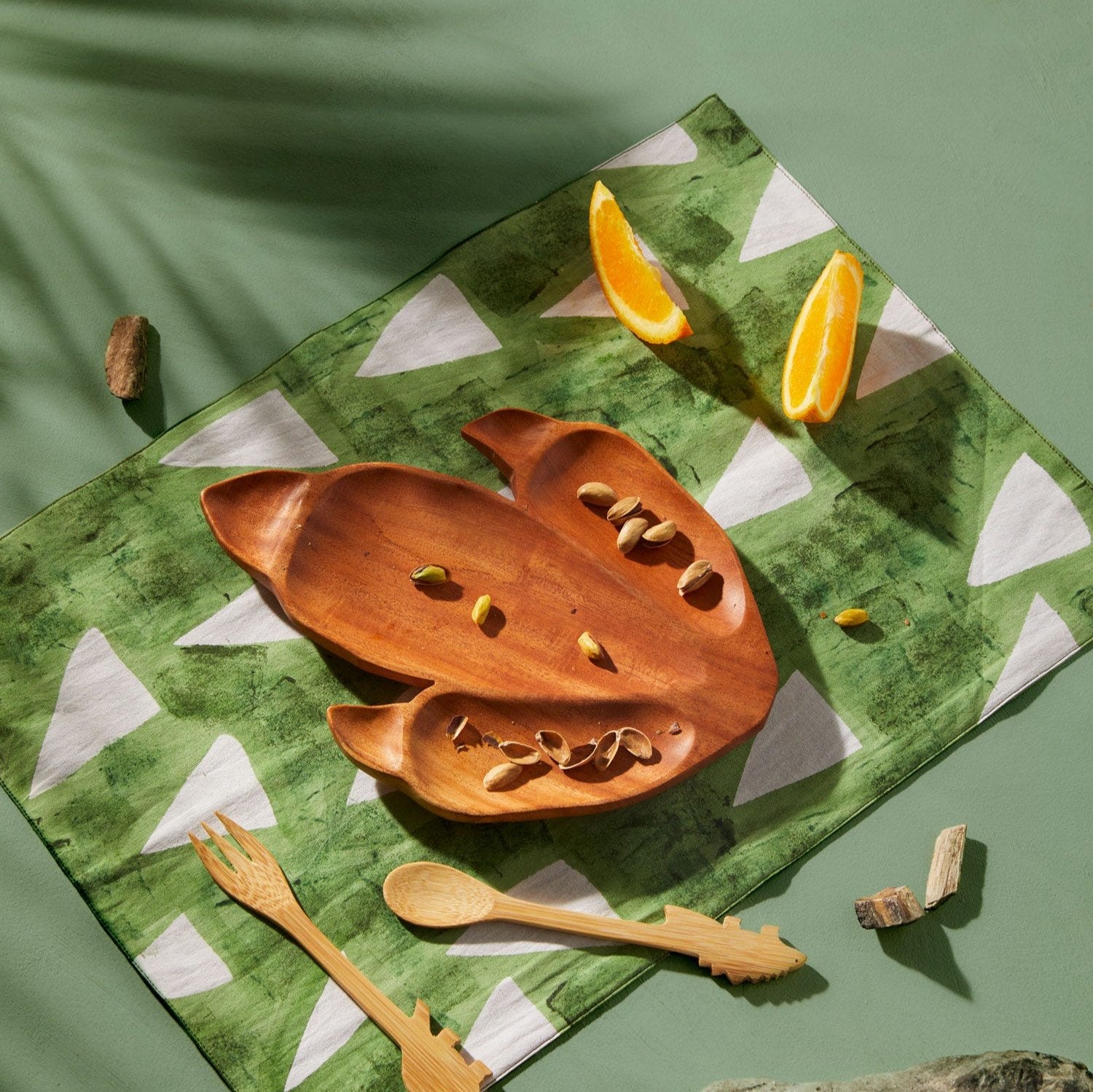 Close-up of handcrafted dinosaur placemat with green and white Stegosaurus design