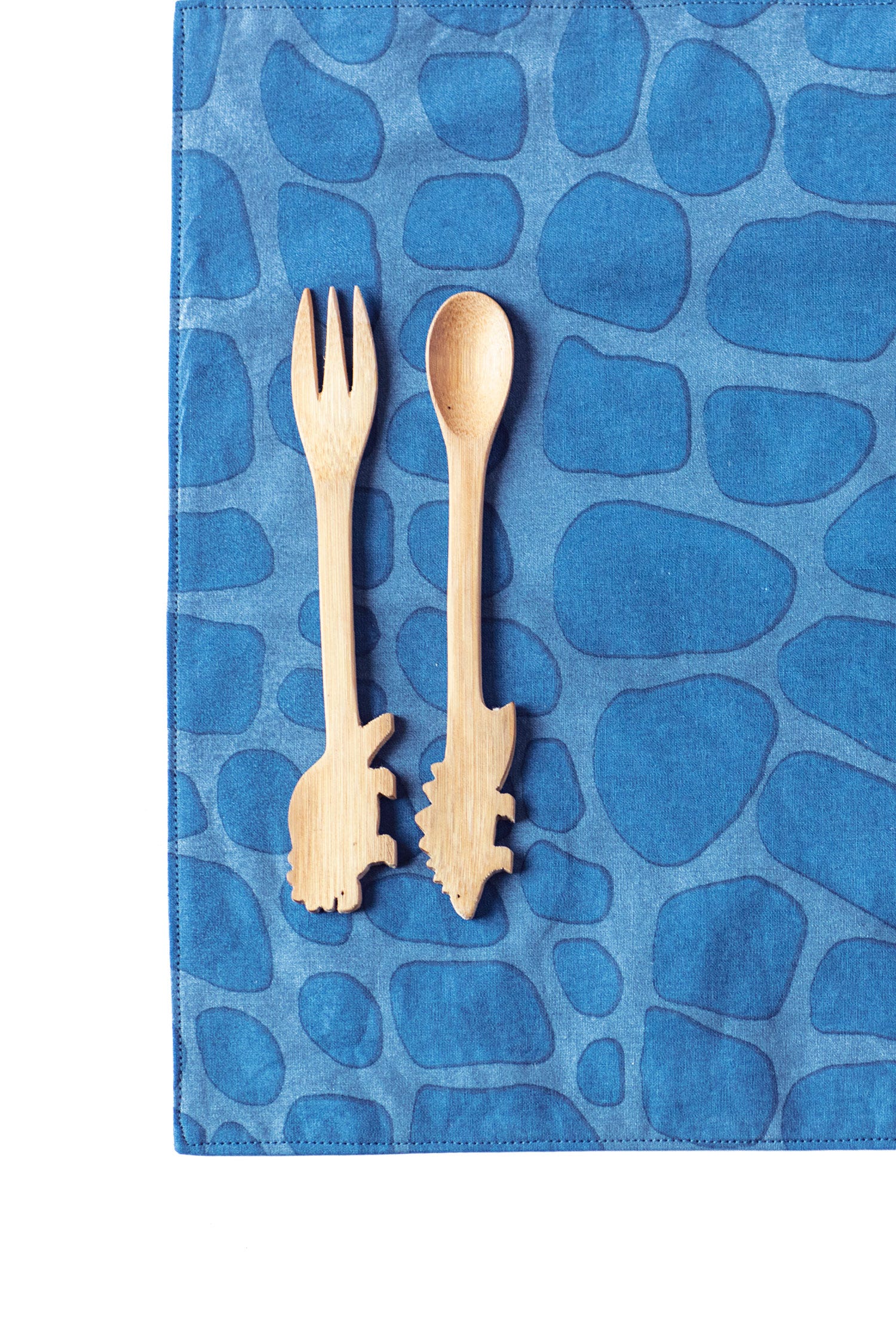 Close-up of the blue dinosaur placemat featuring vibrant dino patterns, ideal for kids' tables.