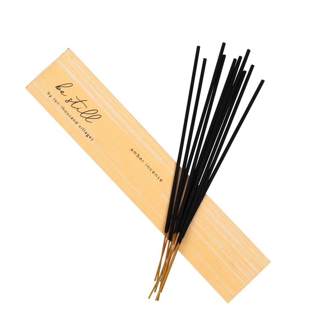 Close-up of amber incense sticks in a decorative holder, ideal for meditation and relaxation