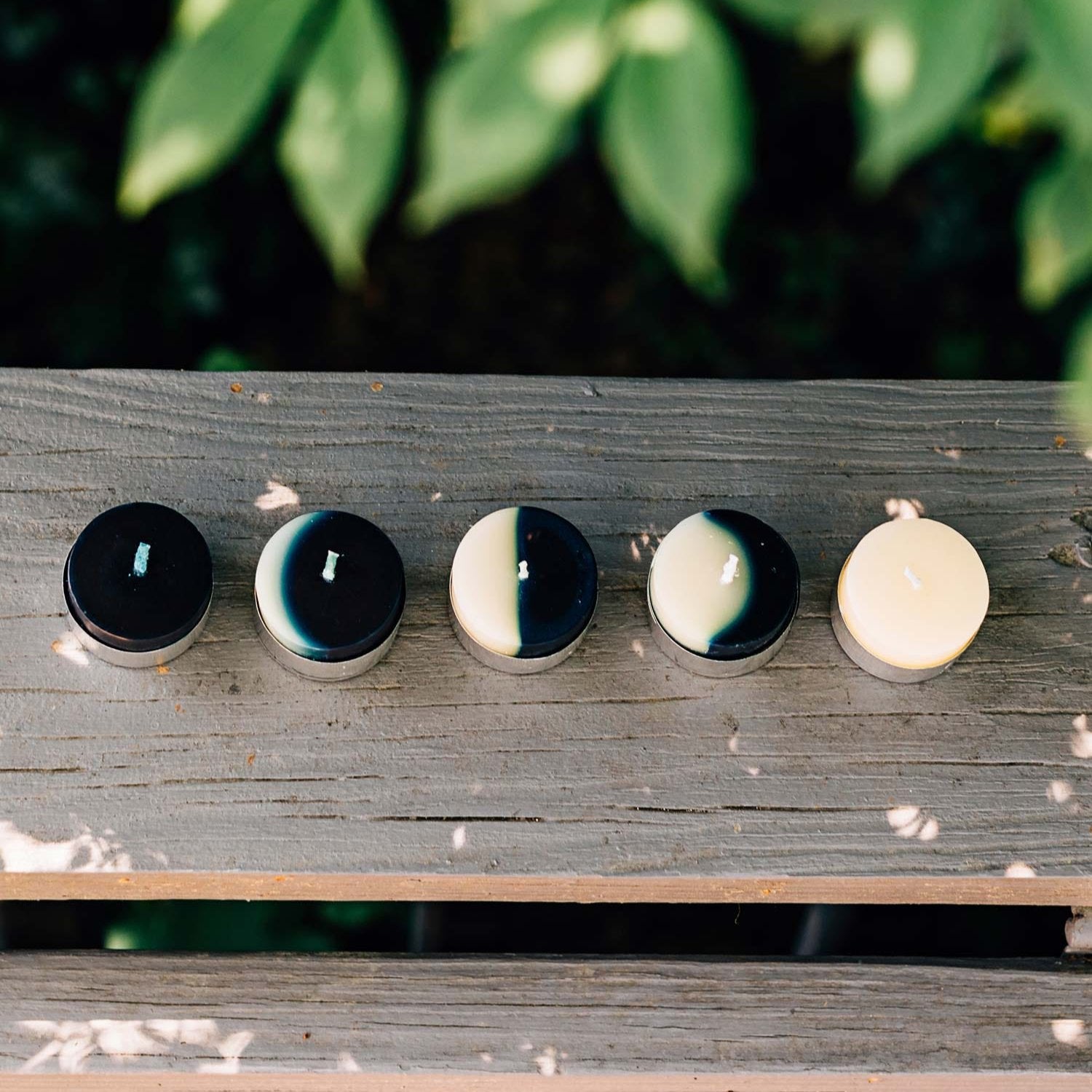Close-up of waxing moon tealights with scented candles in natural light