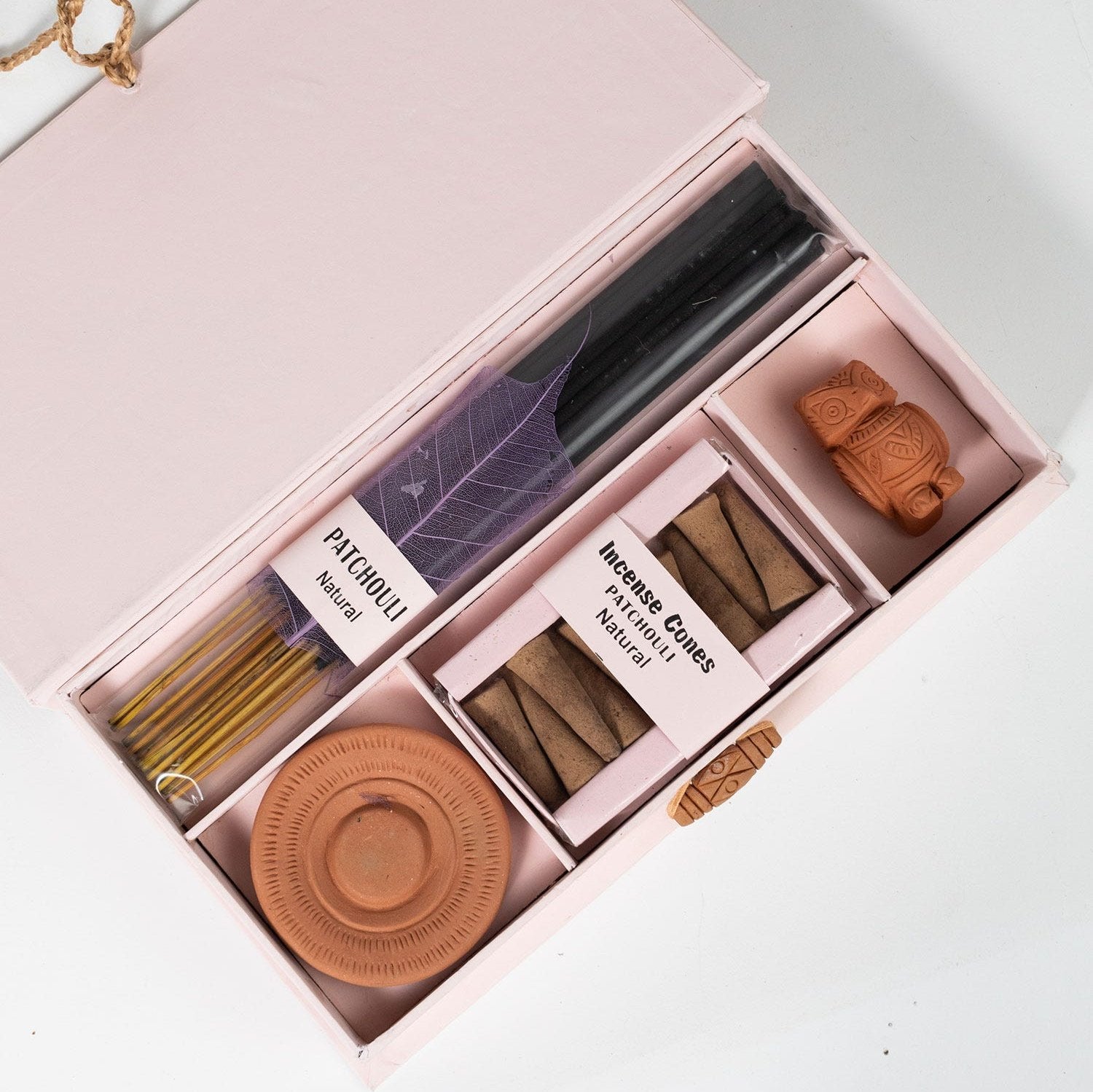 Close-up of patchouli incense sticks in a handcrafted holder for home fragrance