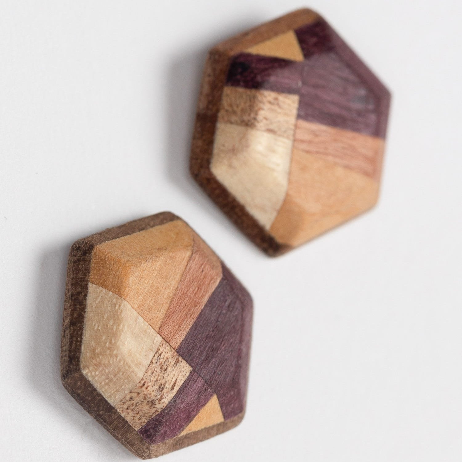 Close-up of eco-friendly wood hexagon stud earrings showcasing natural grain