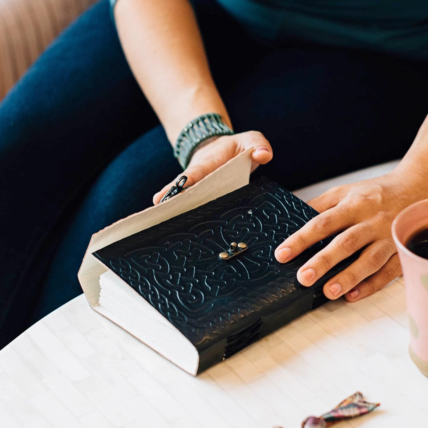 Embossed leather journal with a metal closure, perfect for personal use.