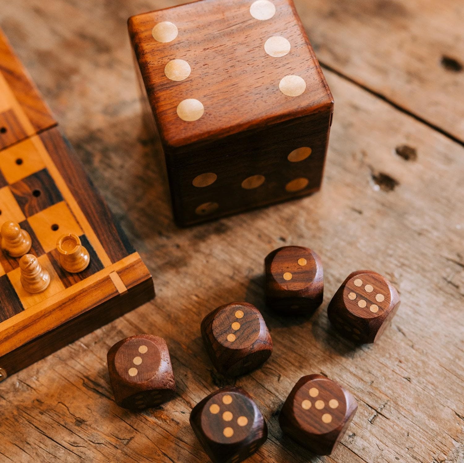 Artisan dice storage case showcasing elegant brass accents and fine wood grain from a side angle.