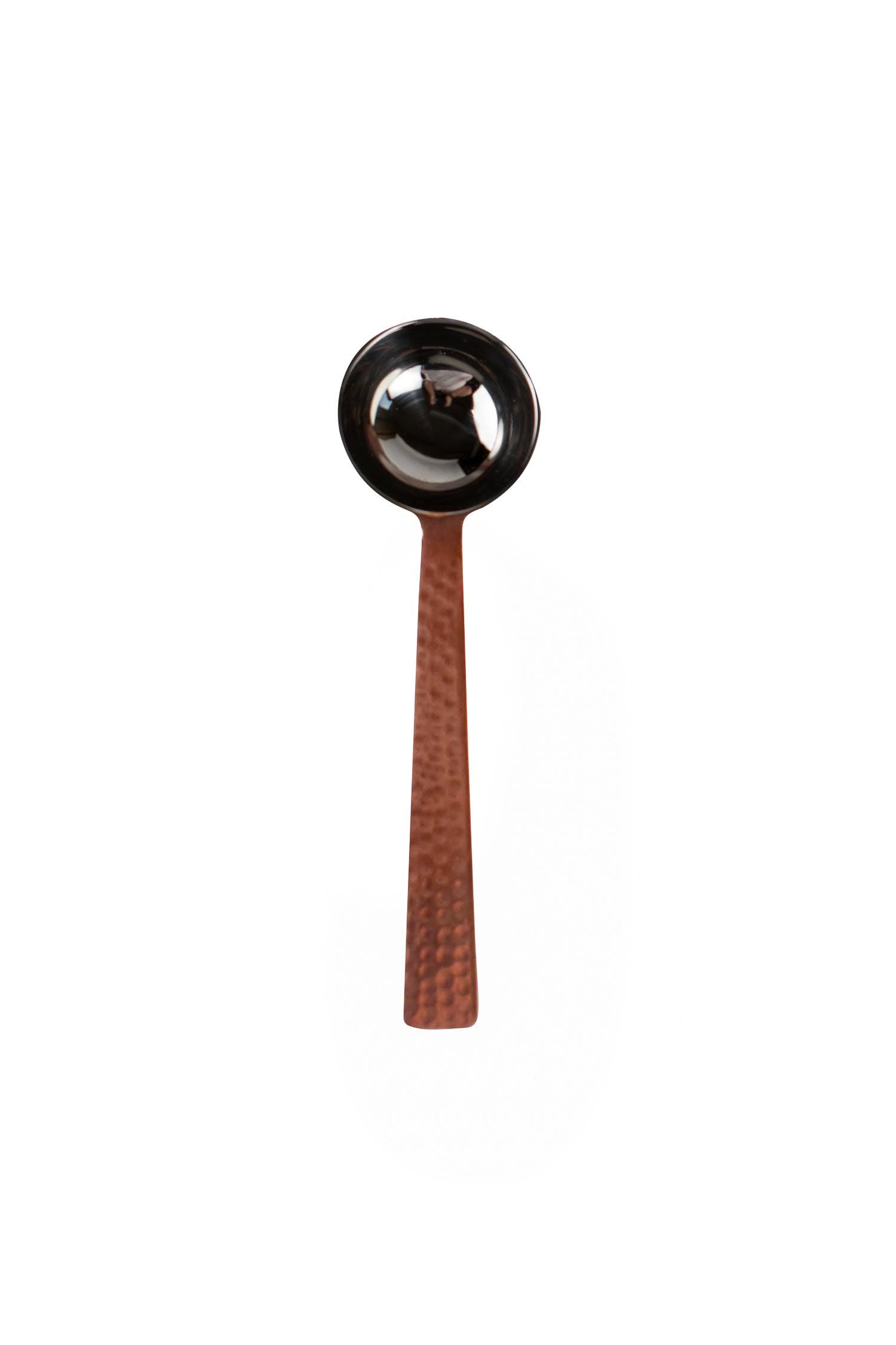 Artisan copper coffee scoop showcasing its handcrafted design and shine.