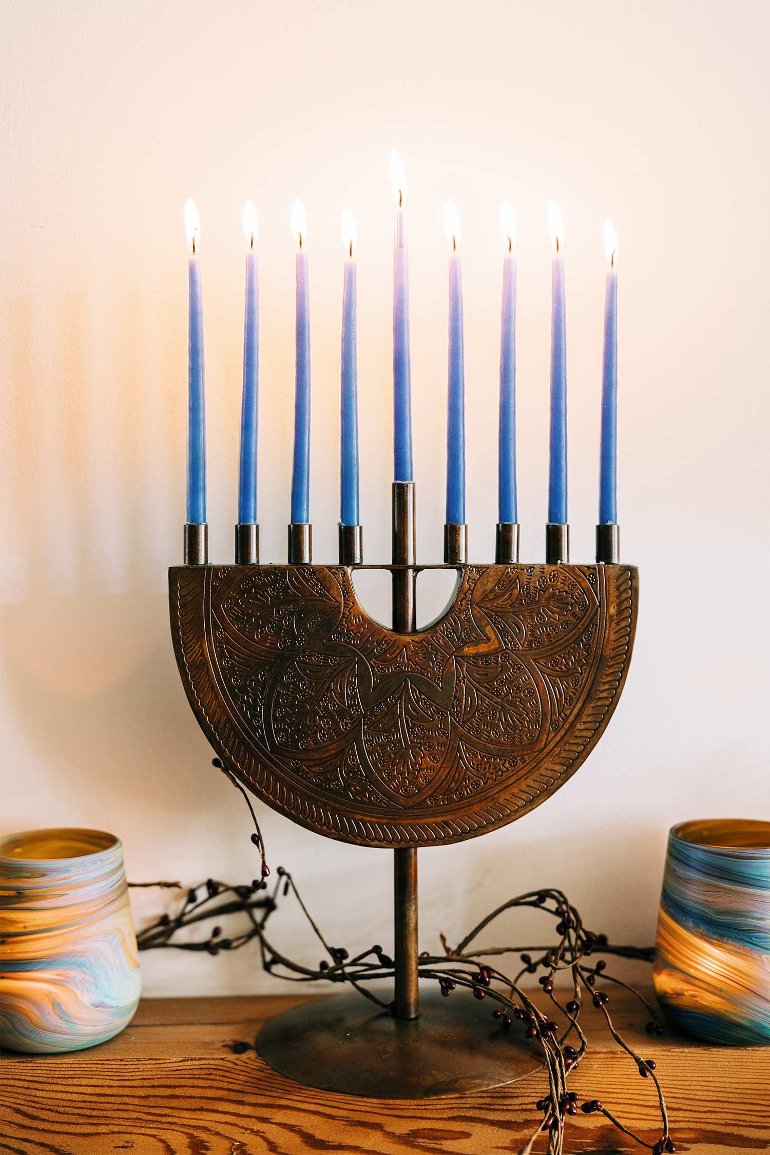 Close-up of engraved details on a handcrafted iron menorah with copper finish