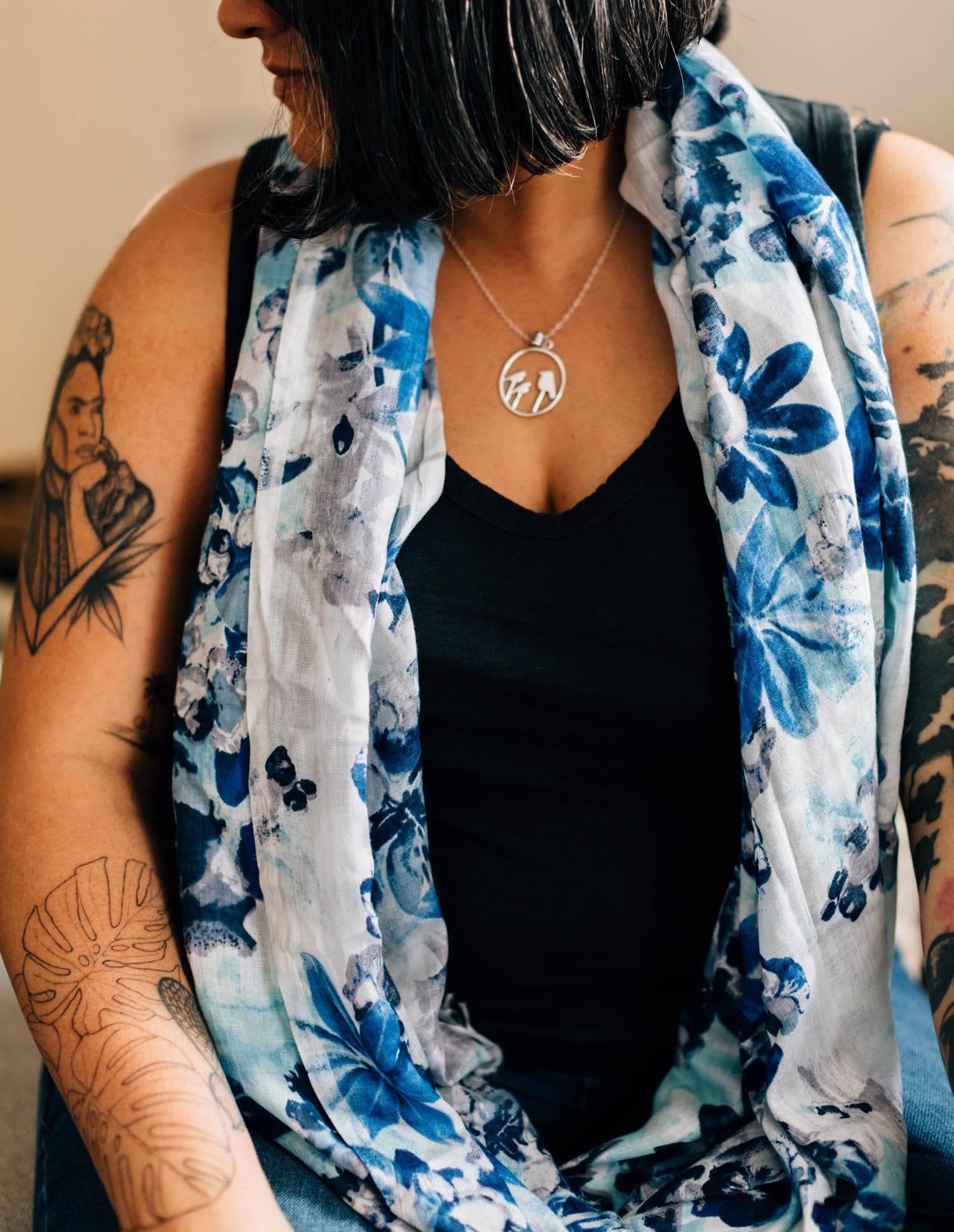 Front view of handcrafted blue scarf with floral design on model