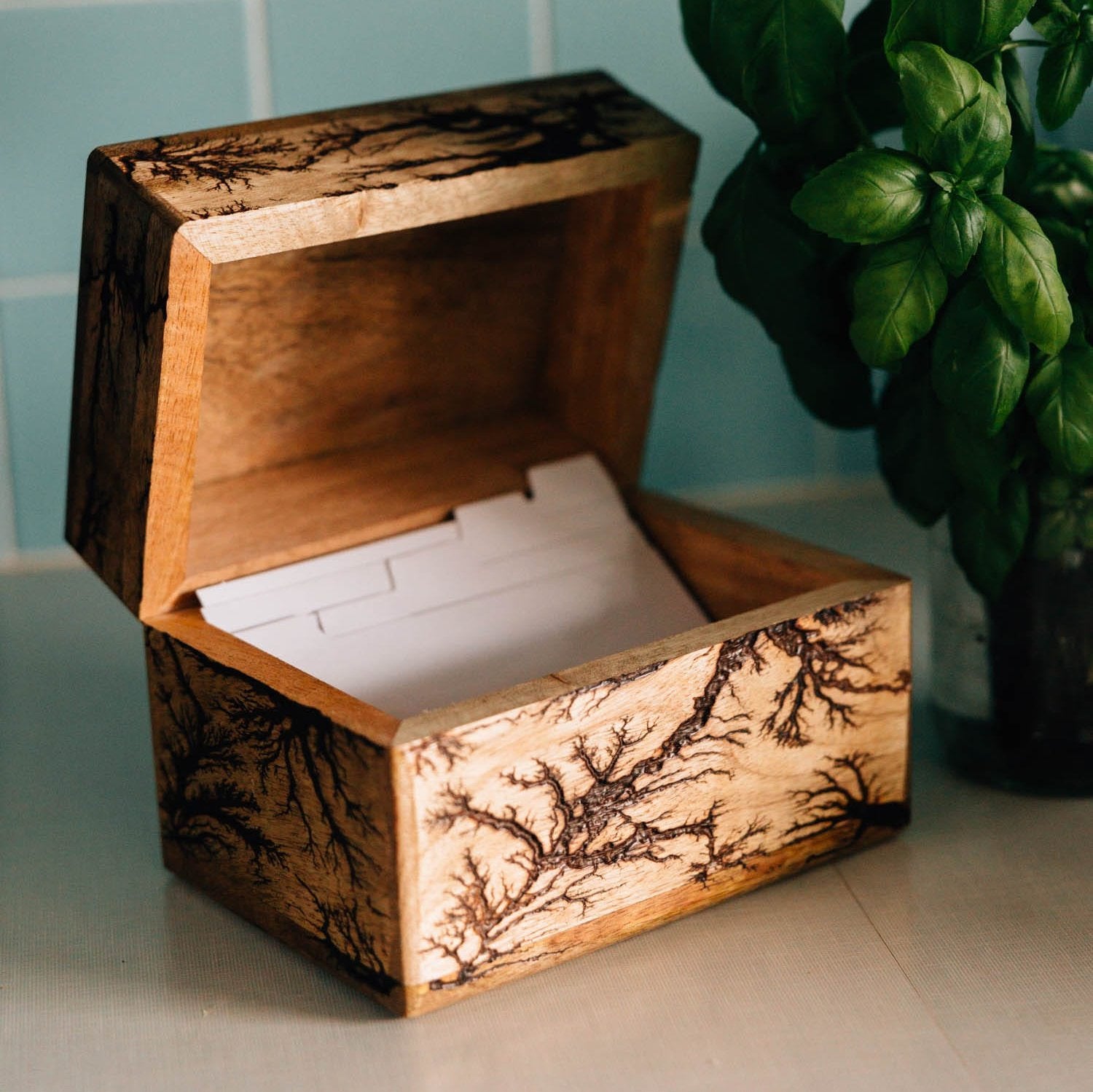 Close-up of handcrafted recipe box with roots motif engraving for organization