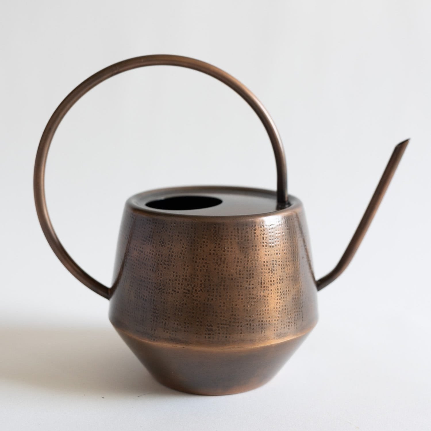Handcrafted antique copper watering can with a long spout and smooth handle