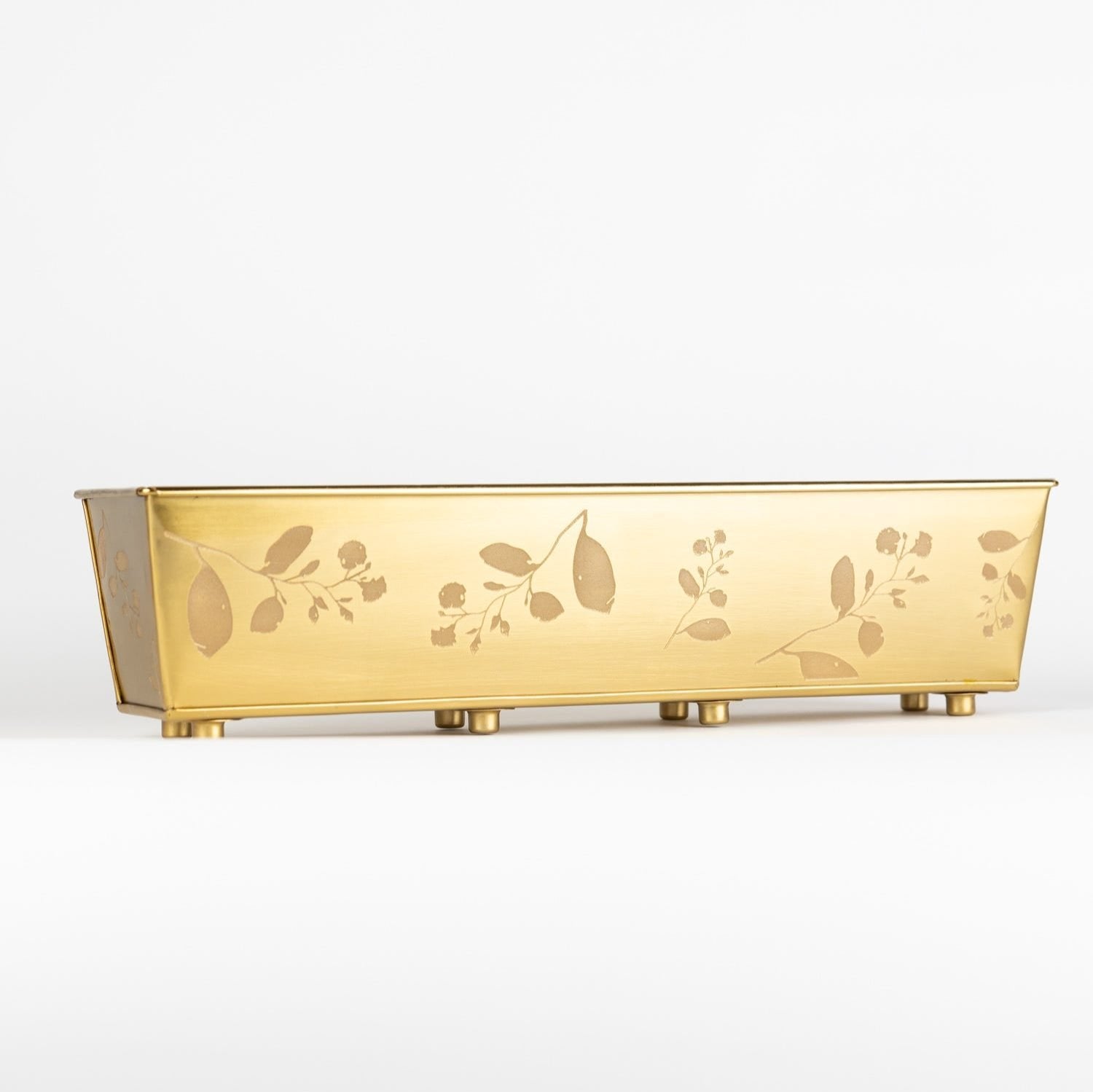 Brass windowsill planter showcasing herbs against a sunny window.