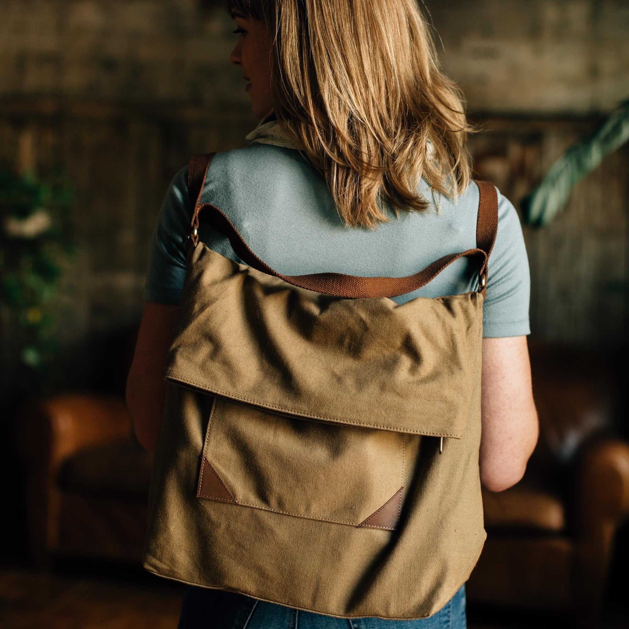 Olive canvas travel bag with leather accents, front view