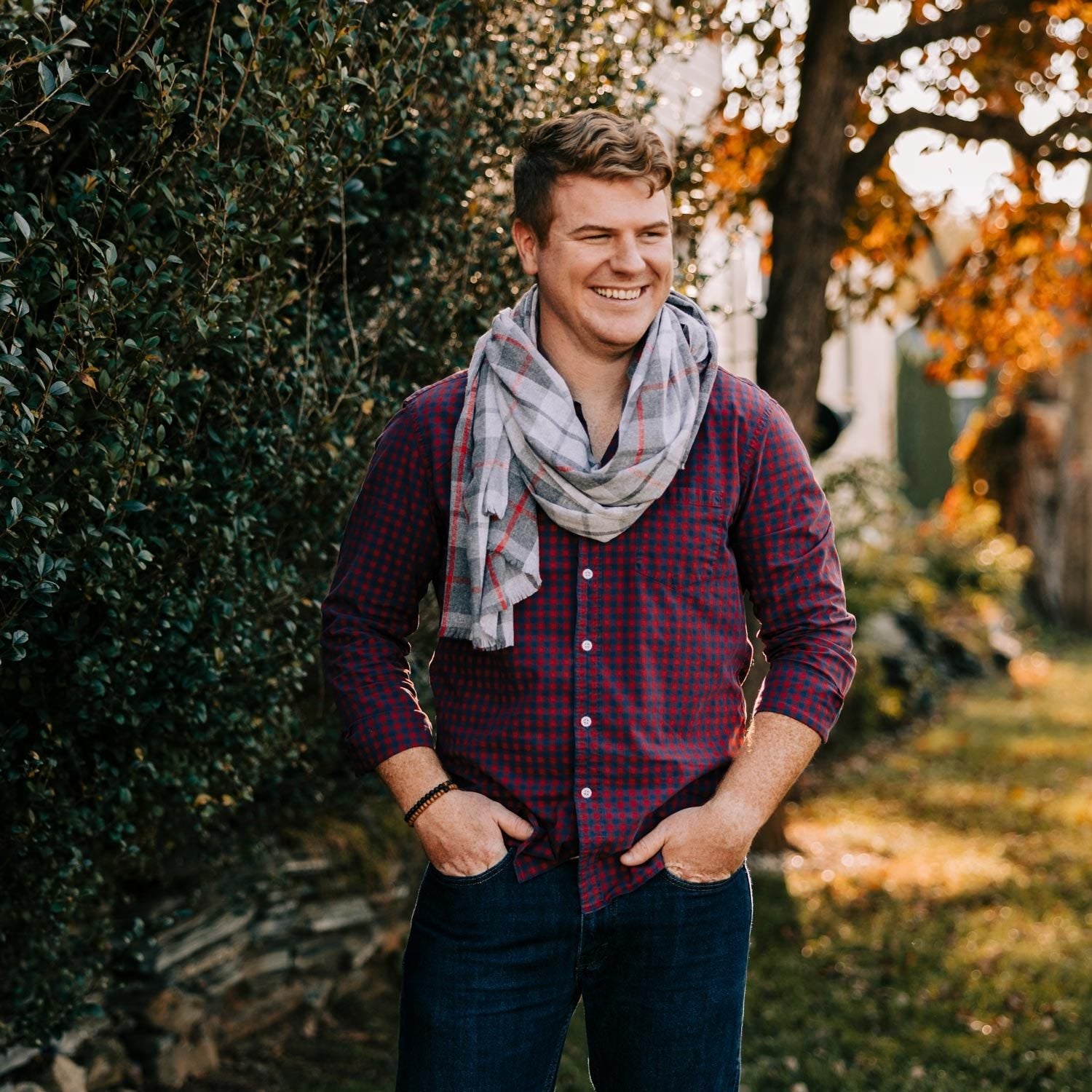 Close-up of the Harbor plaid scarf showing the red stripe and fringe detail