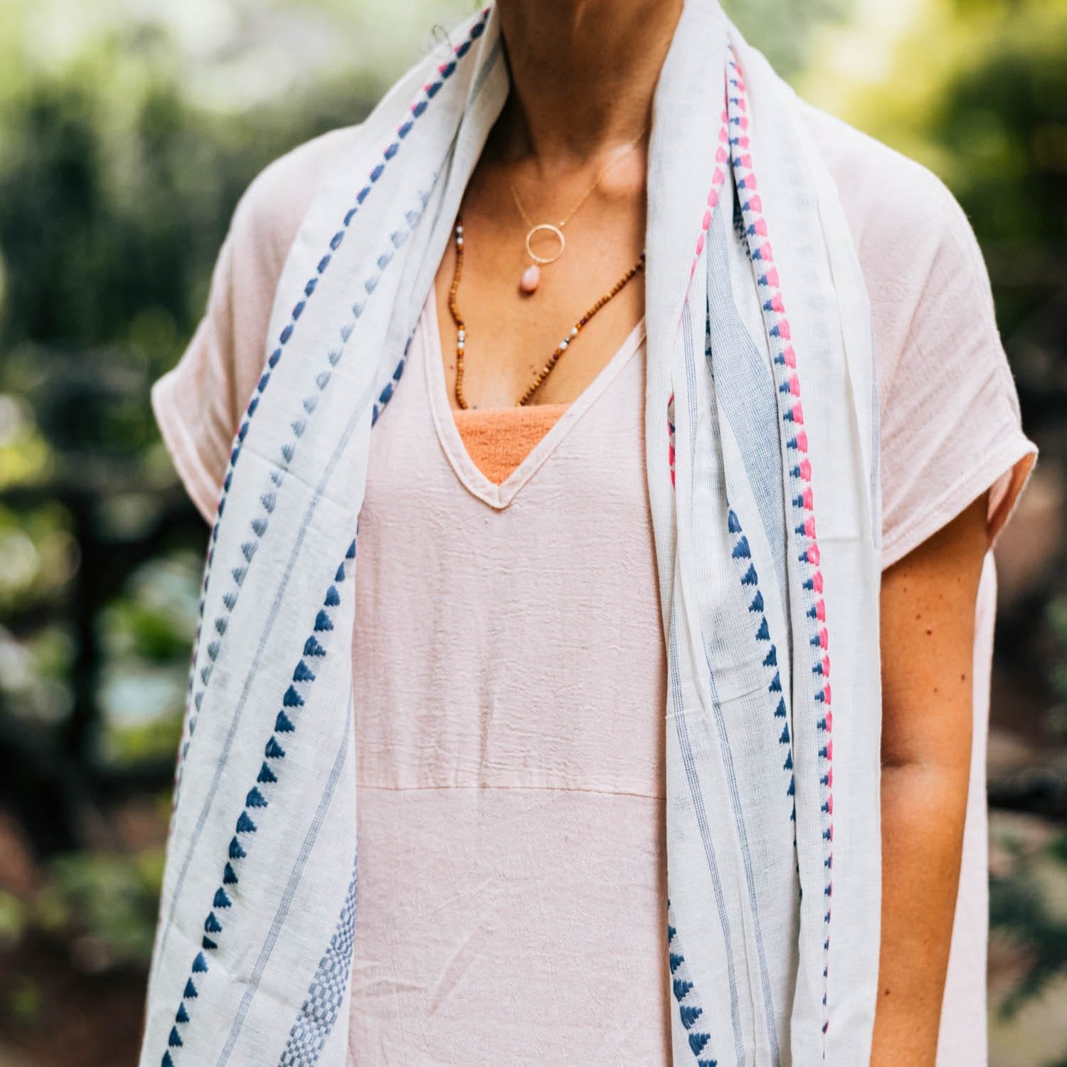 Pink and blue nautical stripe summer scarf draped over a casual outfit