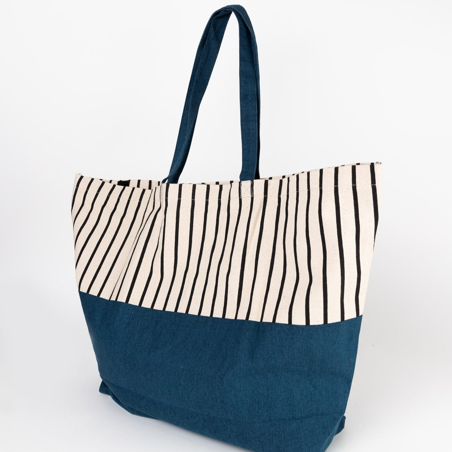 Tropical Vibes Cabana Tote displayed on a sandy beach with vibrant stripes.