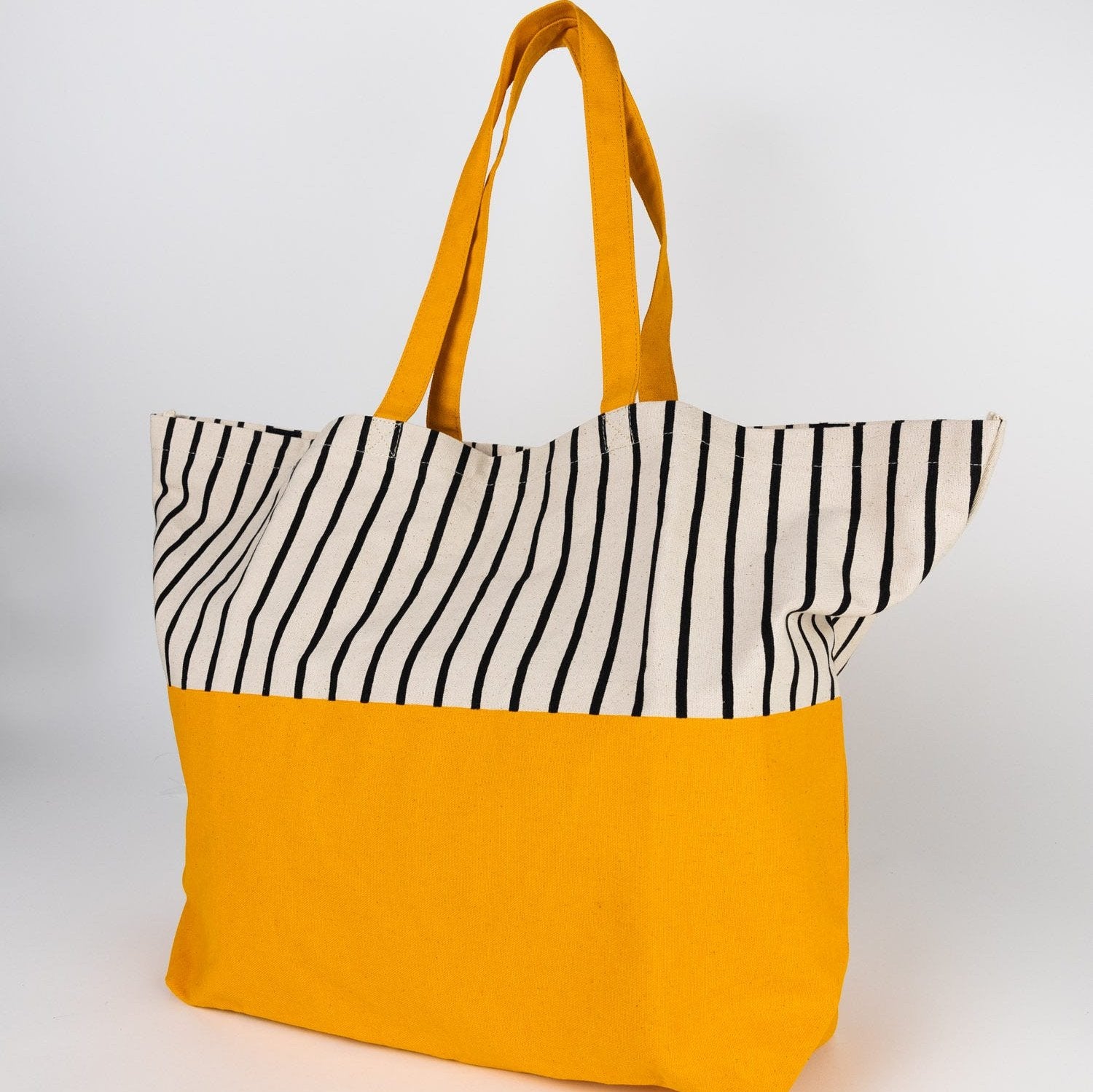 Vibrant organic cotton beach tote with tropical stripe design, ideal for beach trips