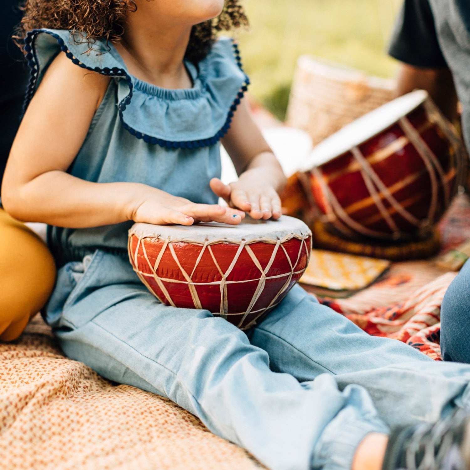 A close-up of the Joybeat Red kids drum showing handcrafted detail and vibrant color