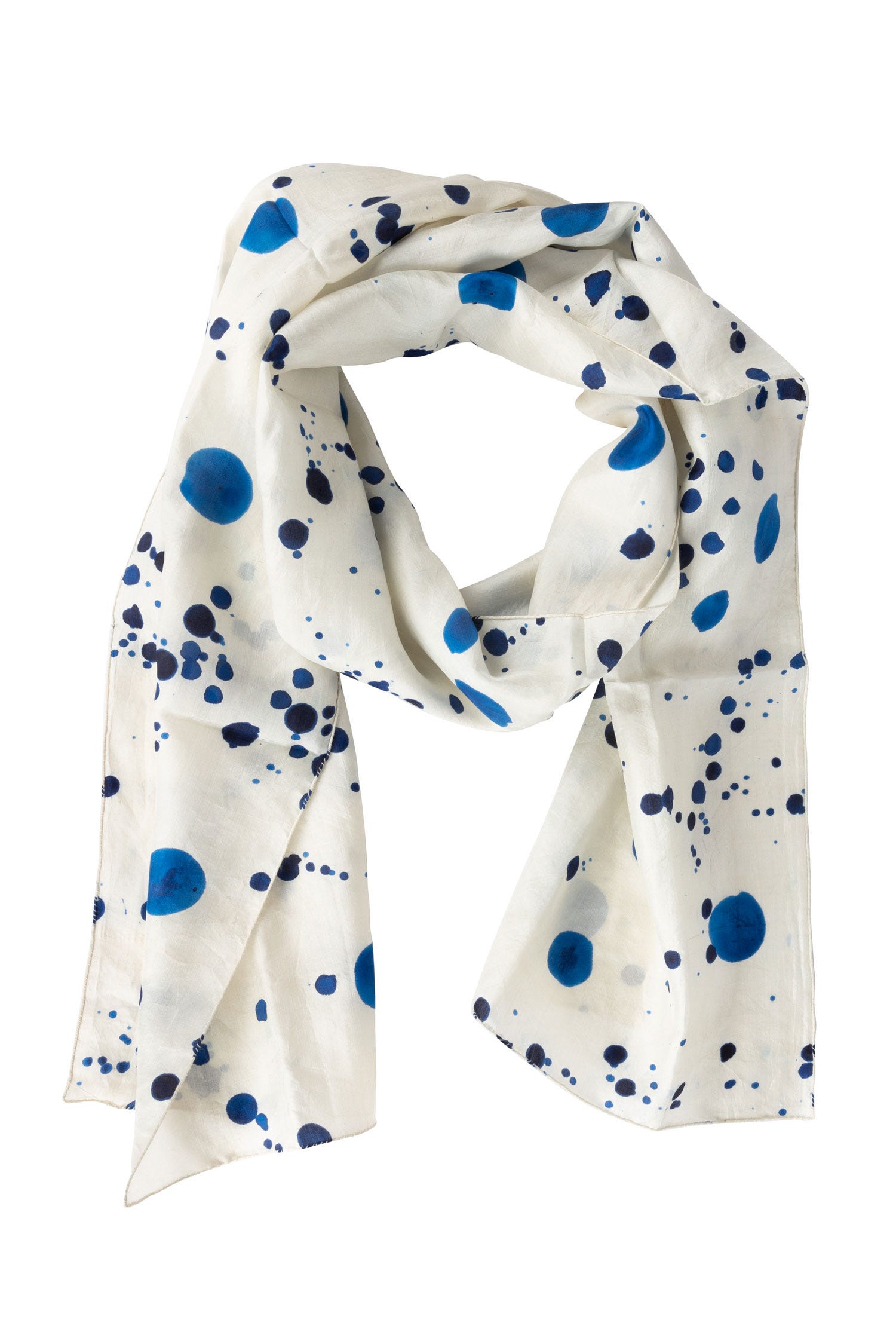 Elegant ink splatter silk scarf draped elegantly over a white blouse, showcasing its vibrant colors.