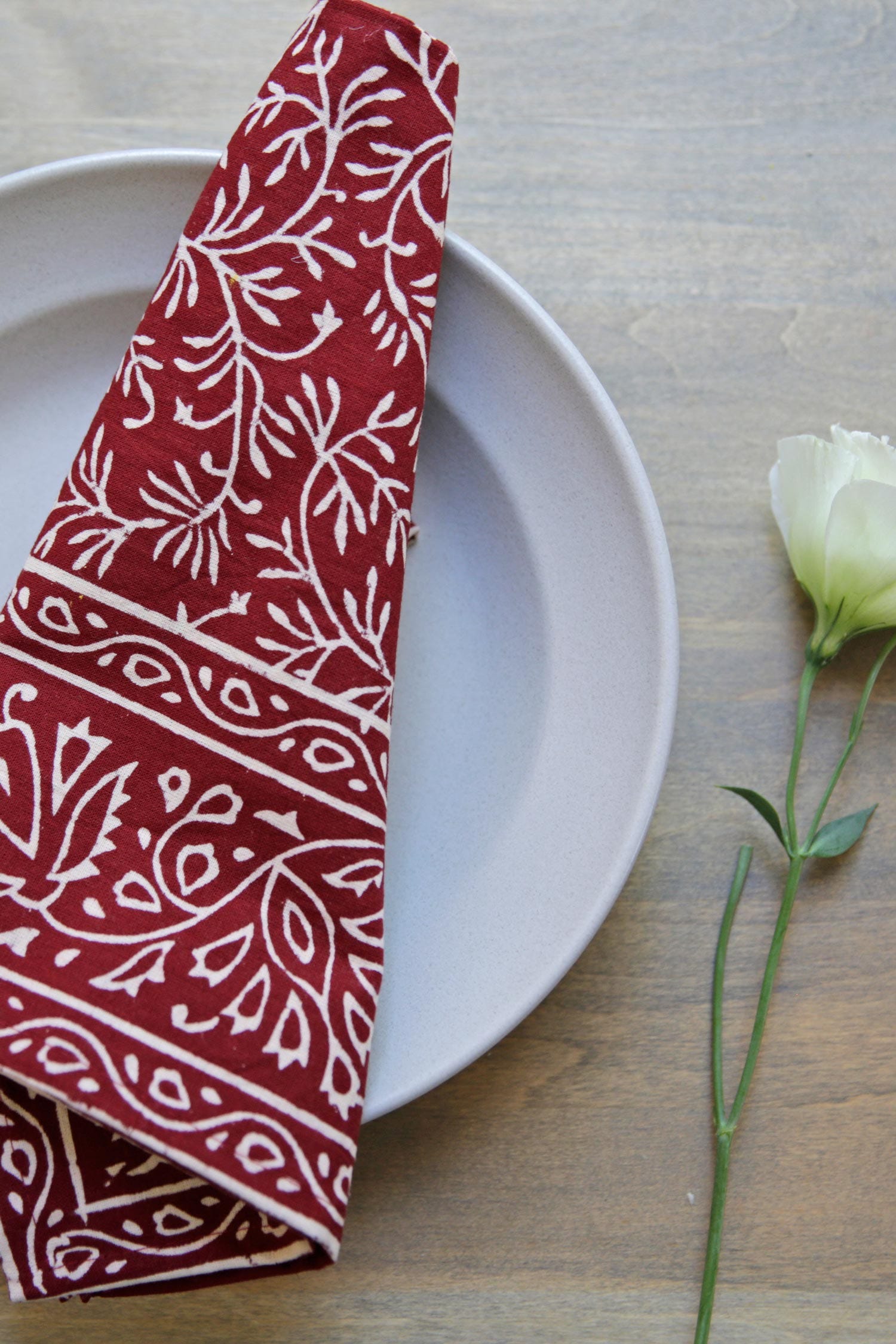 Close-up of handcrafted cotton napkins with vine design for holiday table decor