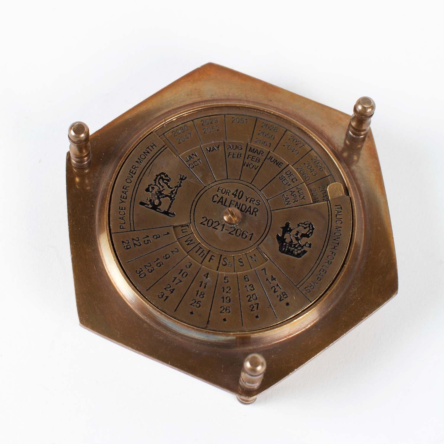 Antique brass compass and calendar set displayed on a desk, showcasing its elegant design.