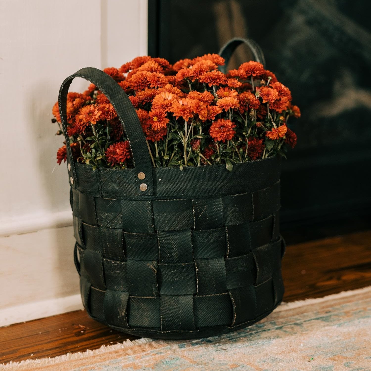 Close-up of woven recycled tire rubber tote with sturdy handles, ideal for garden tools