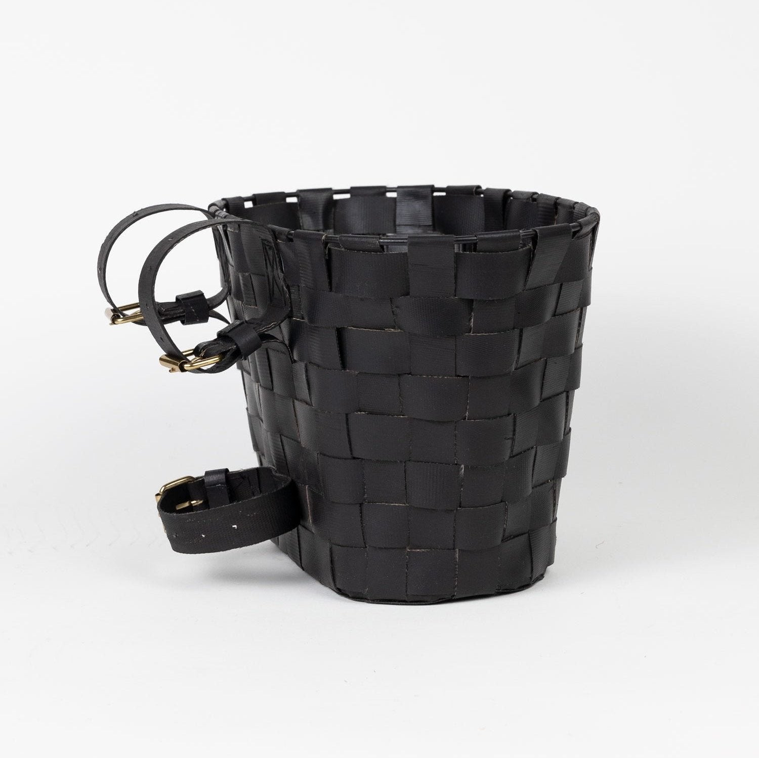 Close-up of recycled tire bike basket on city bike, showing eco-friendly material and adjustable straps