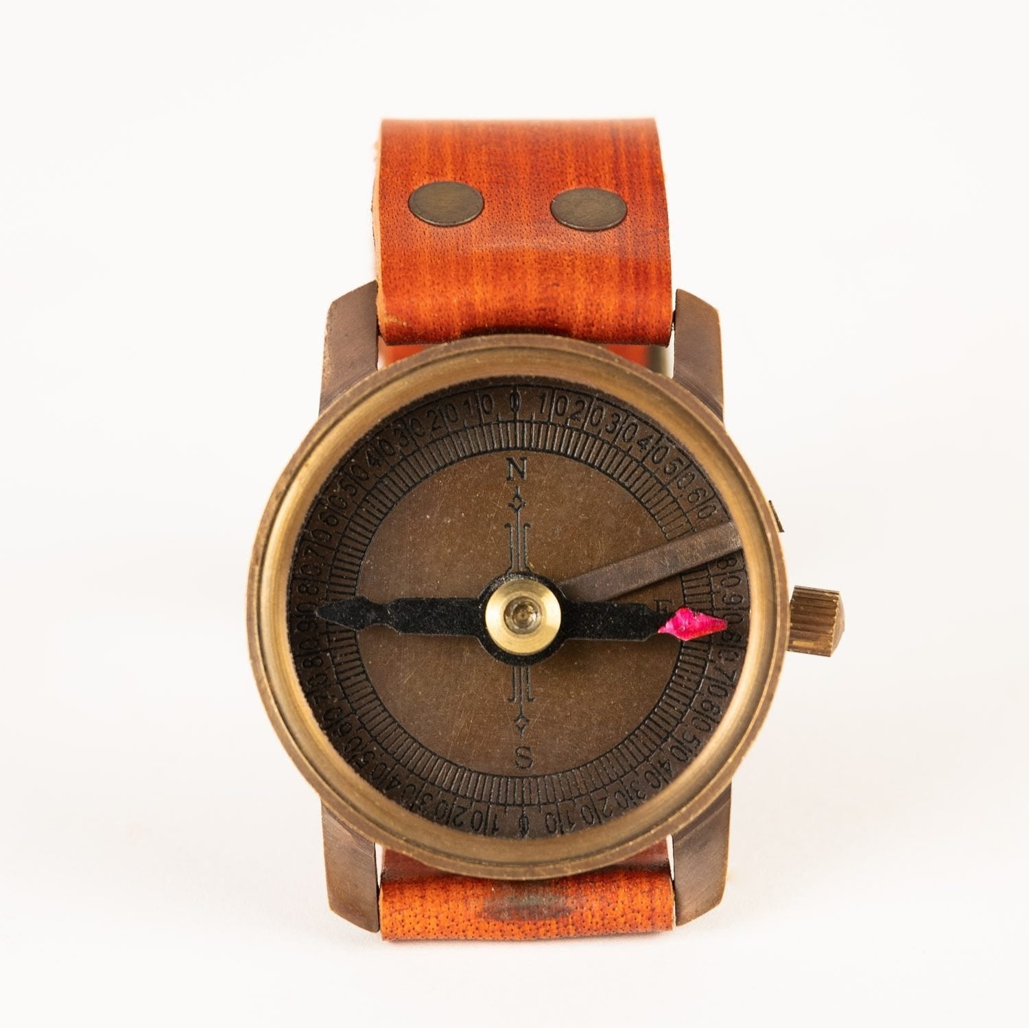 Close-up of handcrafted brass travel compass with leather strap on wrist