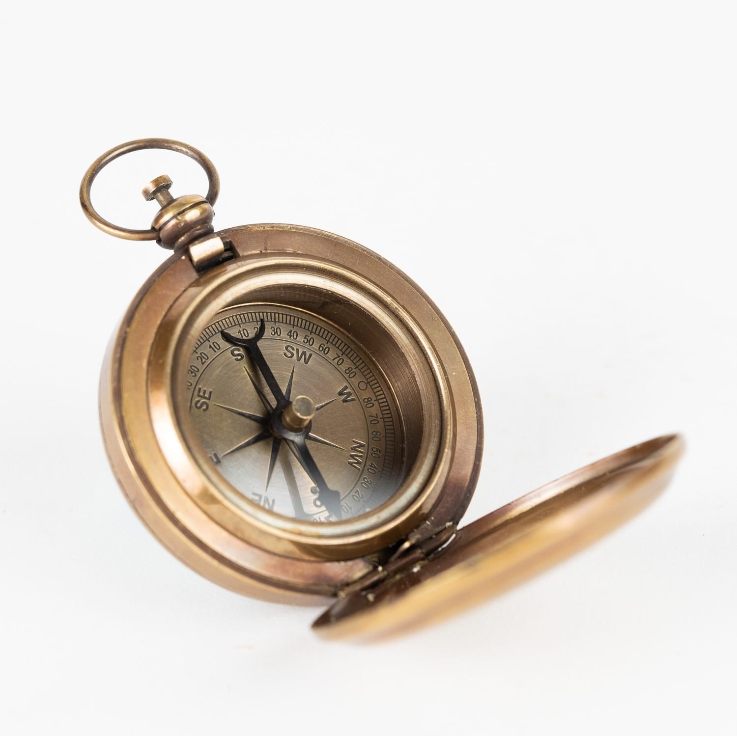 Close-up view of the Navigator's Brass Pocket Compass showcasing its etched anchor design.