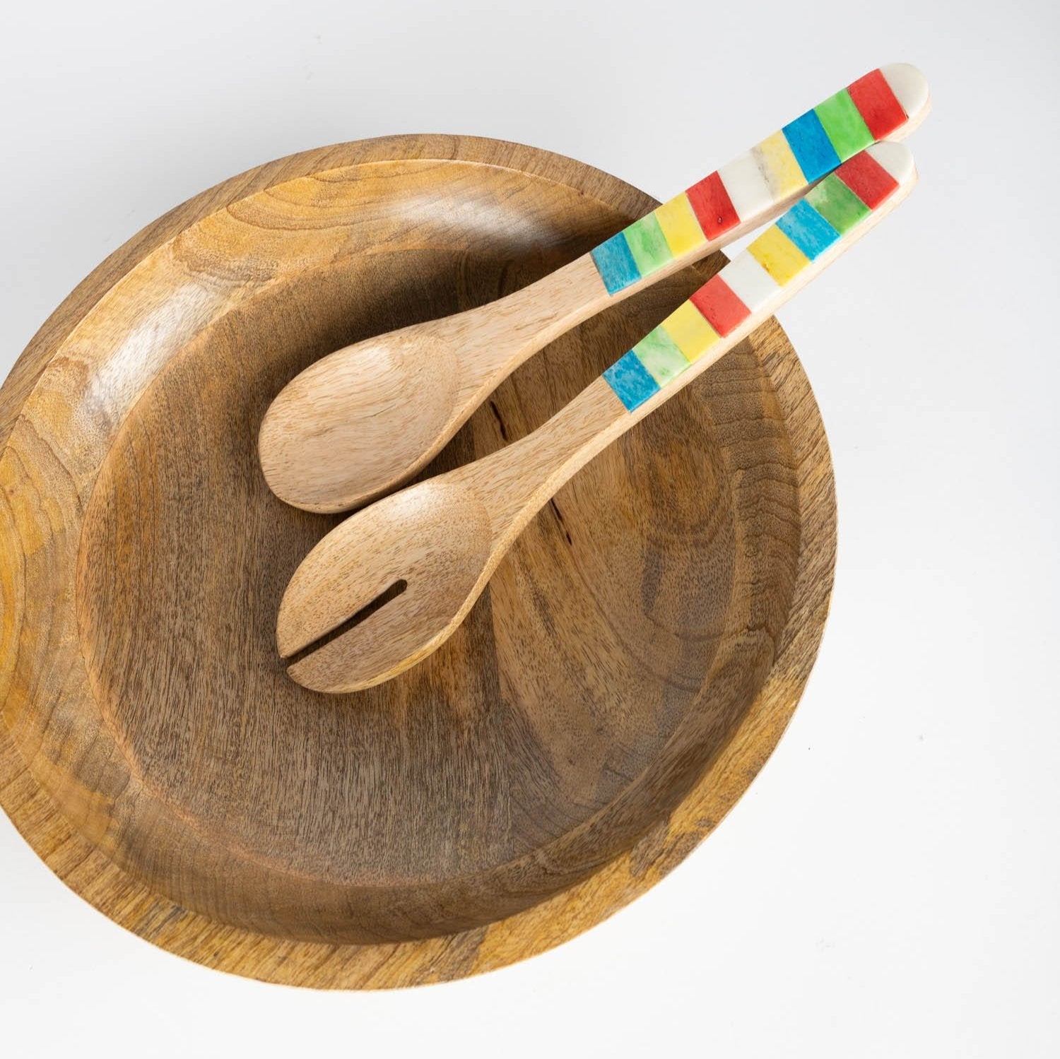 Close-up of mango wood salad servers with inlay detail showing vibrant colors and craftsmanship