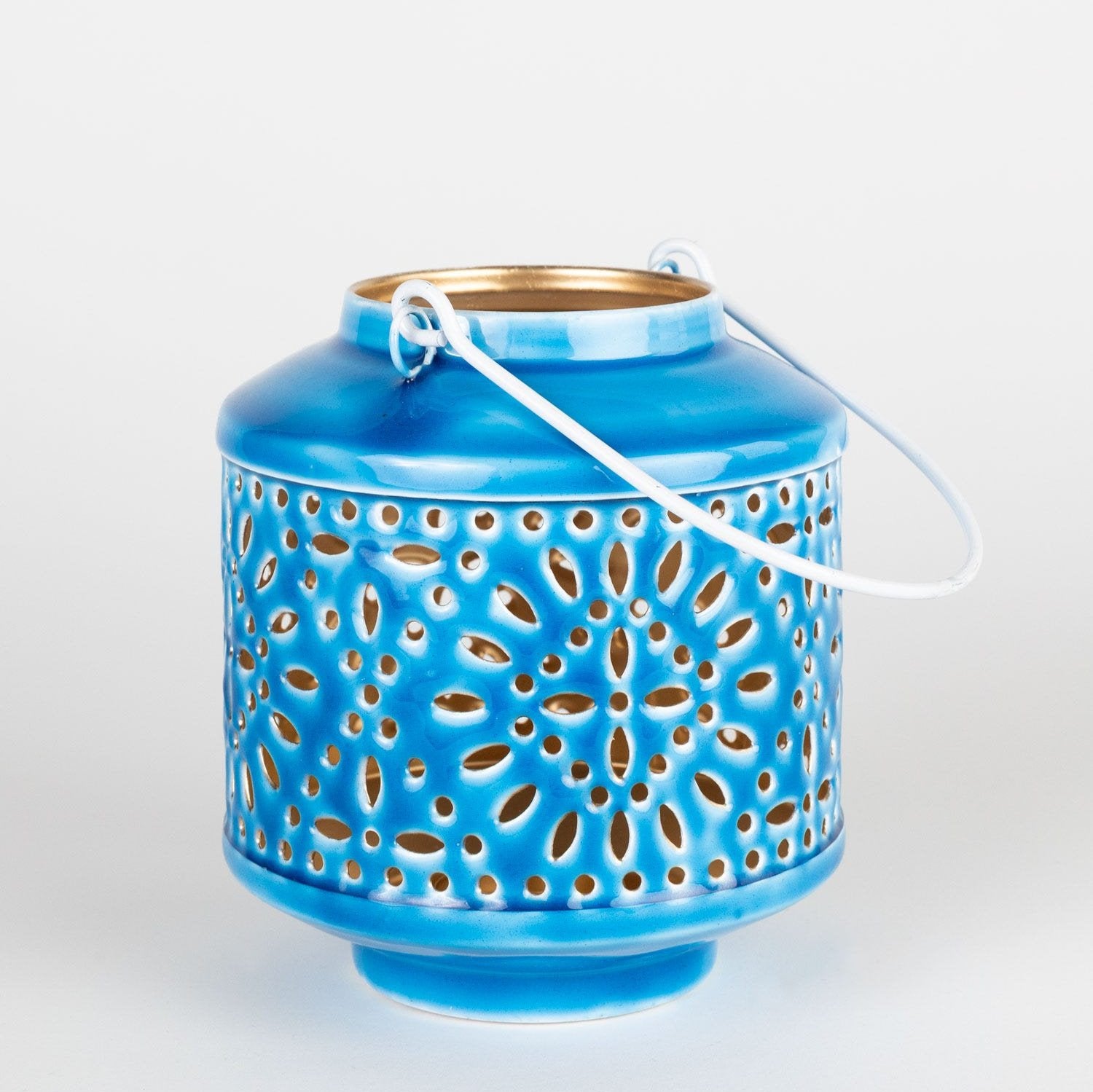 Close-up of blue hanging iron lantern with decorative cutouts and gold interior for outdoor decor