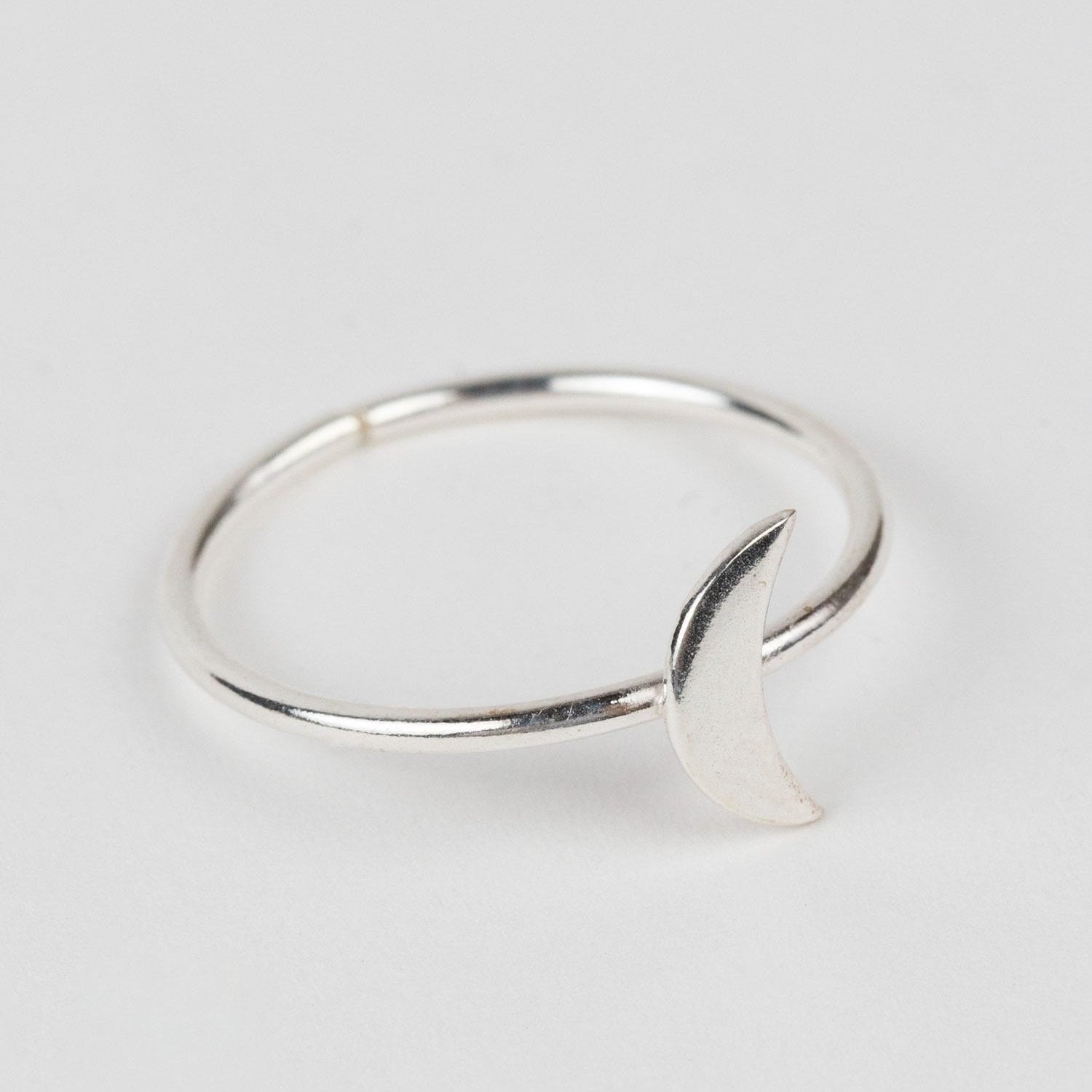 Front view of artisan crafted silver crescent moon ring with celestial design