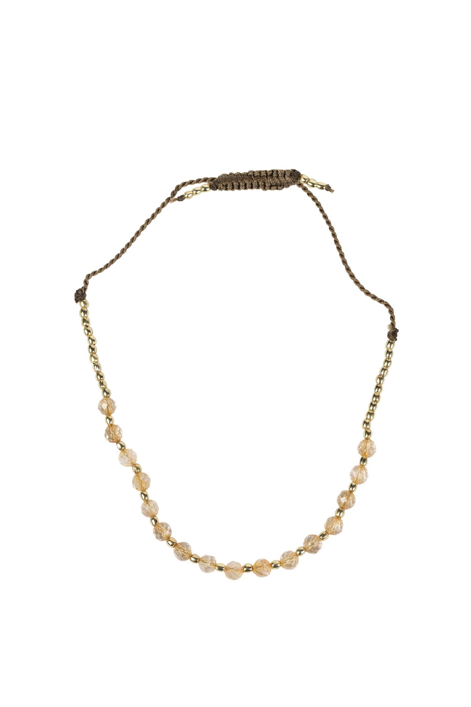 Top-down view of the citrine bracelet resting on a linen cloth, showcasing the golden beads and adjustable closure