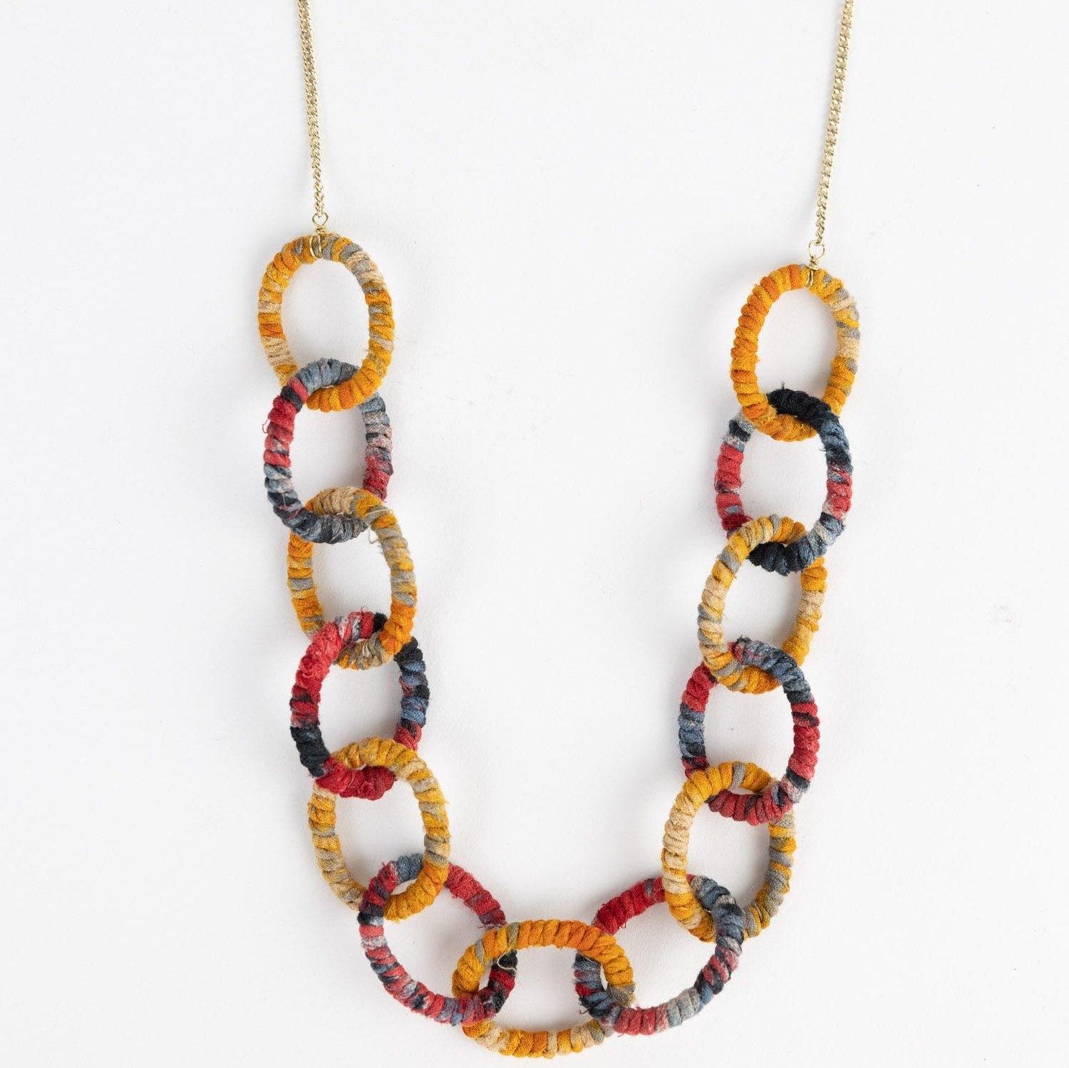Close-up of vibrant sari fabric links on statement jewelry