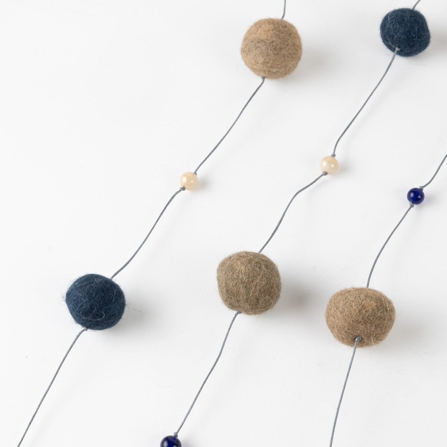 Eco-friendly felt garland draped over a mantle, showcasing its vibrant colors and handmade glass beads.
