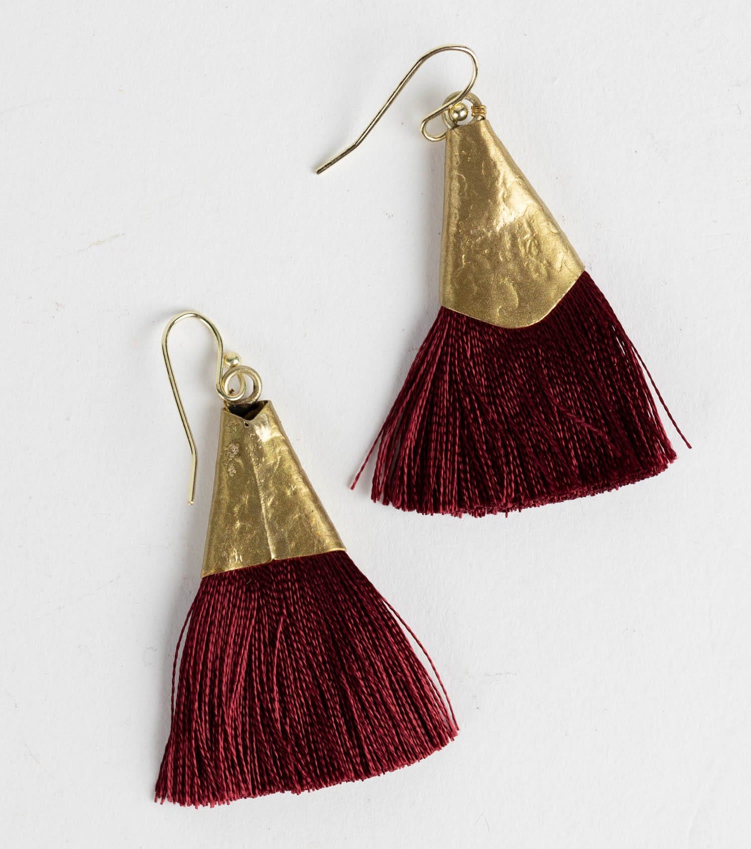 Close-up of hammered brass tassel earrings showcasing artisan craftsmanship