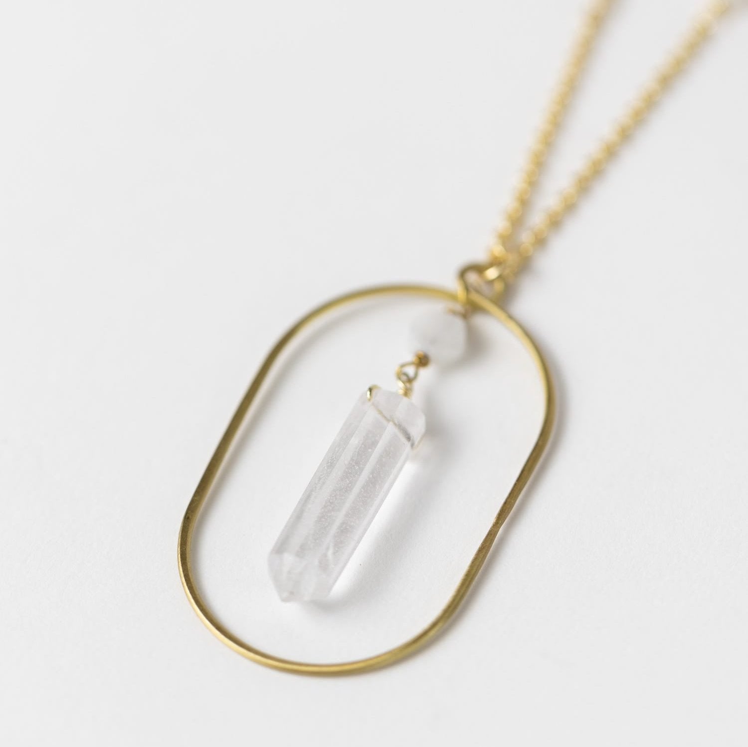 Close-up of the moonstone ellipse pendant on a delicate chain, showcasing craftsmanship