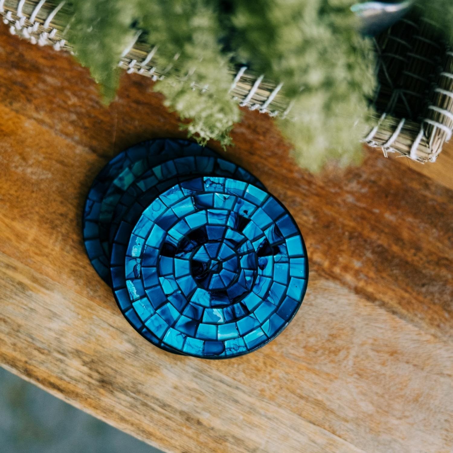 Close-up of handcrafted blue mosaic coaster with shimmering shades of blue