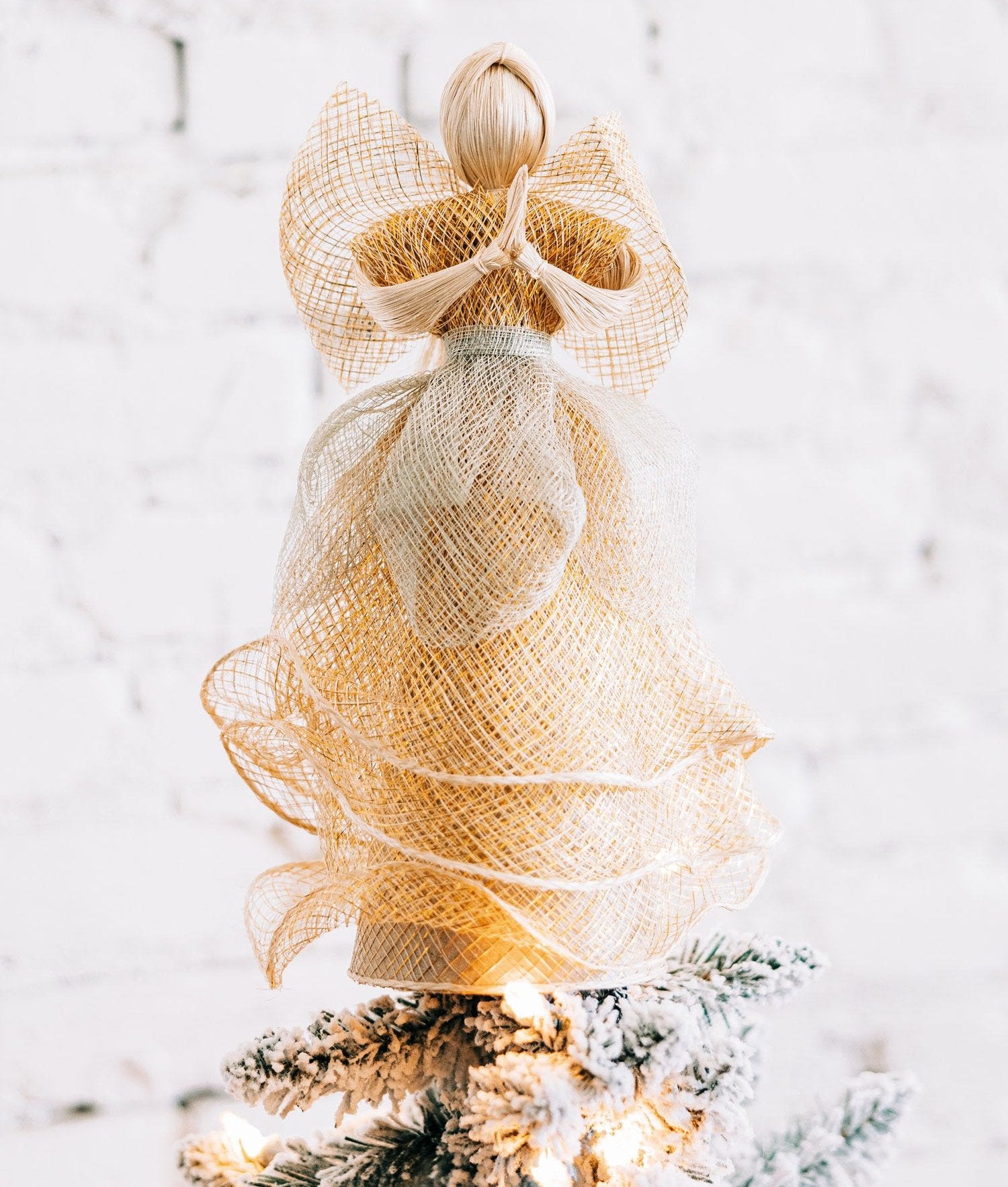 Close-up of the golden angel tree topper with praying hands and gold accents