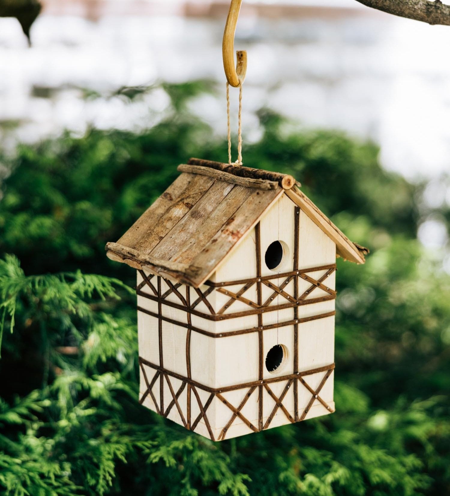 Charming Tudor style birdhouse showcasing its slatted vine roof and gmelina wood side panels.