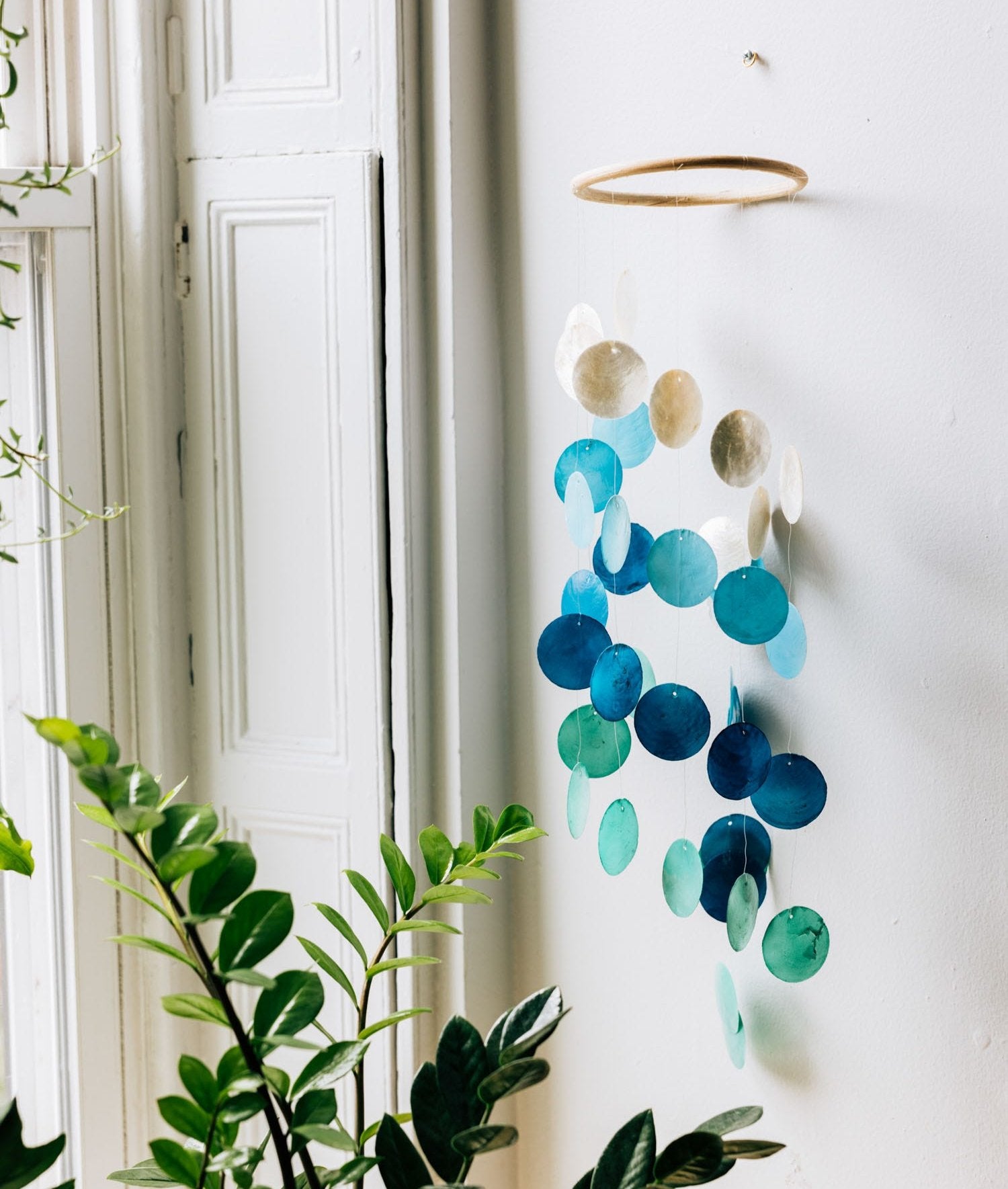 Close-up of spiral capiz shell wind chime hanging in garden