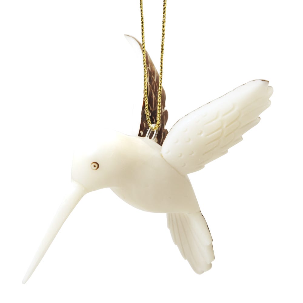 Close-up view of the elegant hand-carved hummingbird ornament, highlighting its intricate details and painted wings.