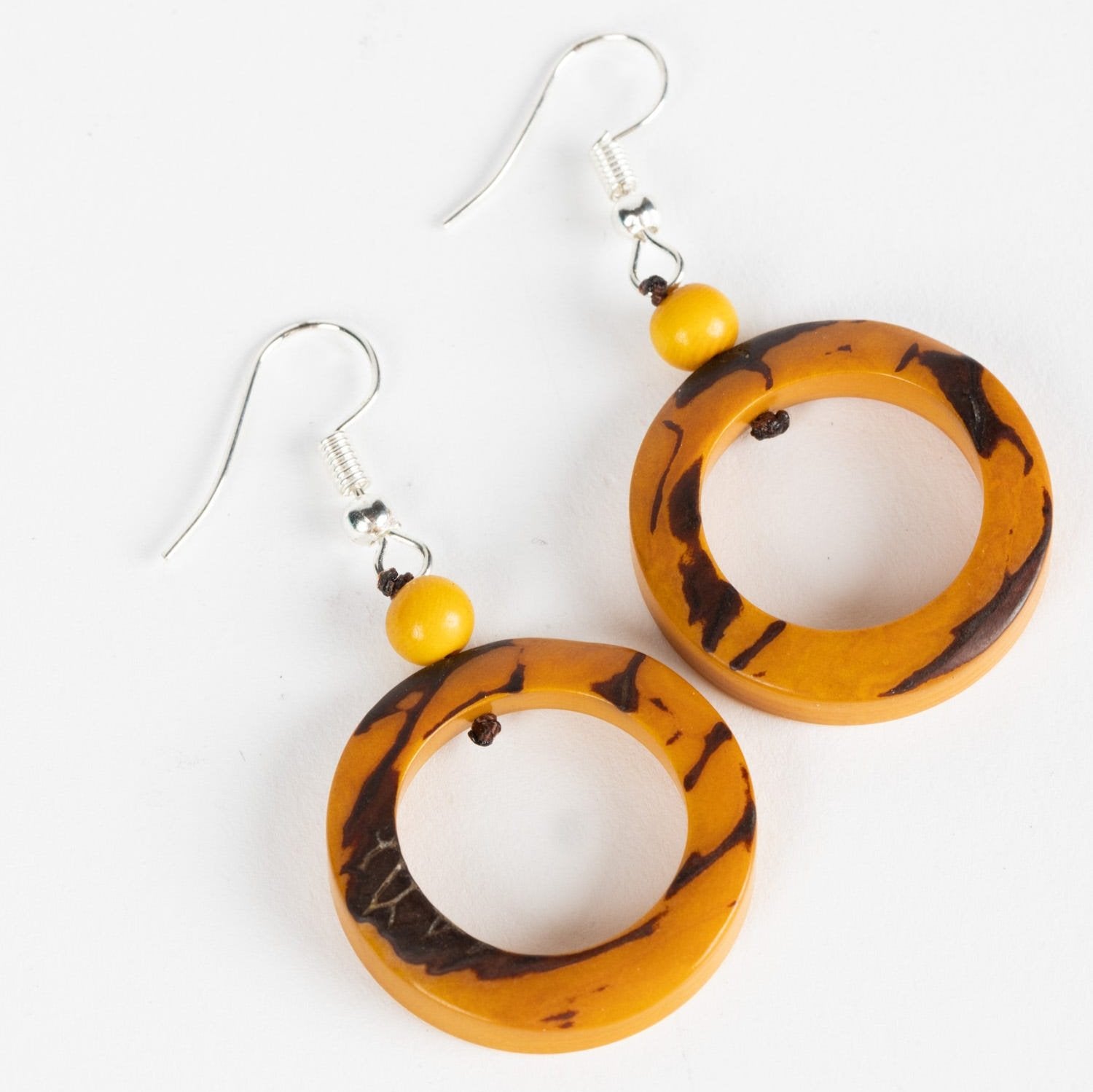 Front view of eco-friendly vegetable ivory earrings on a model's ear