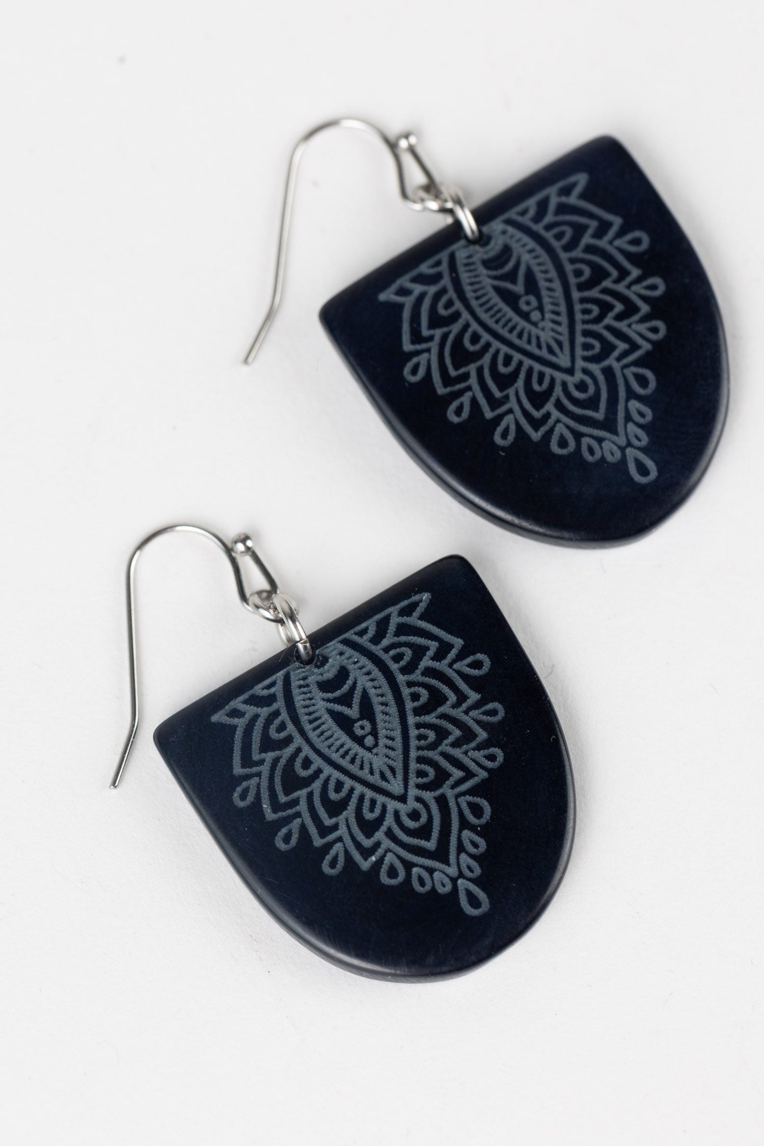 Close-up of handcrafted Ecuadorian tagua earrings showing detailed artisan work