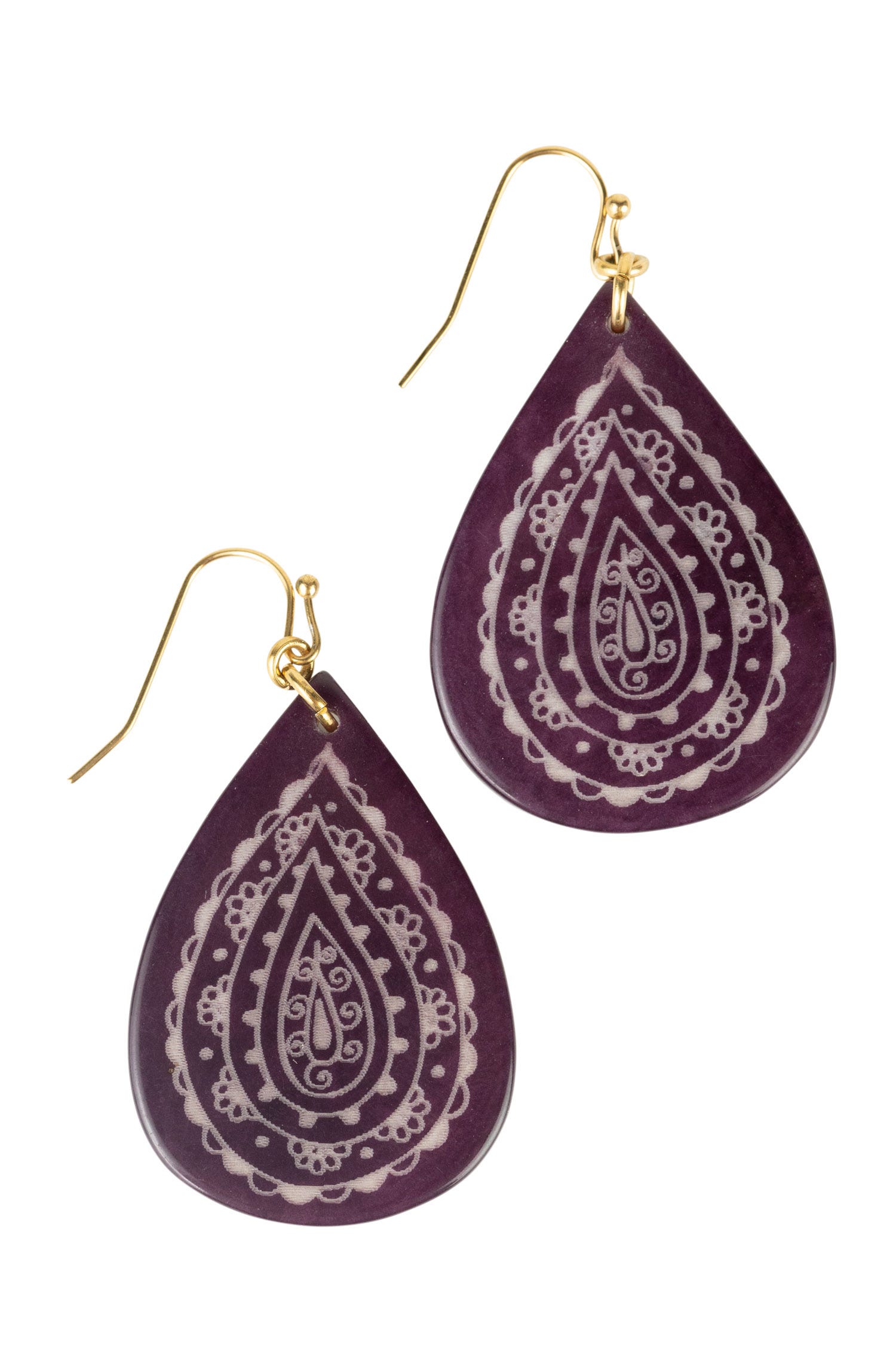 Close-up of eco-friendly tagua teardrop earrings showcasing intricate etching.
