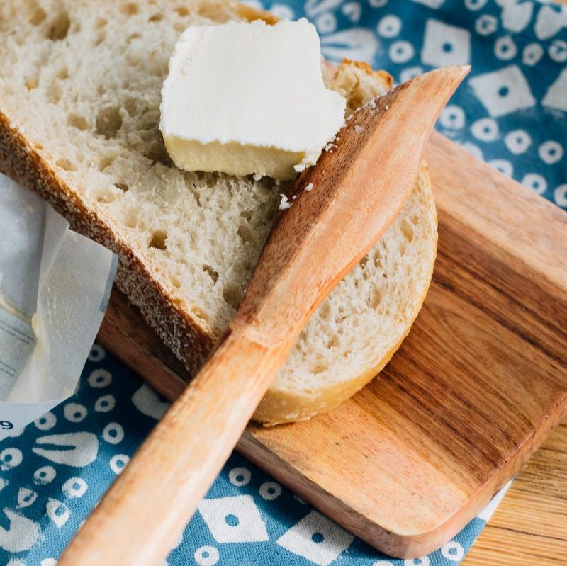 Close-up of the handcrafted wooden serving board with cheese and fruits.