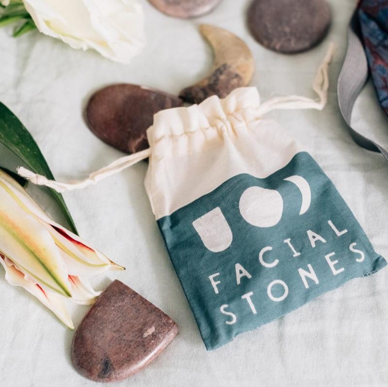 Close-up of the genuine relaxation face massage stone set in a drawstring bag